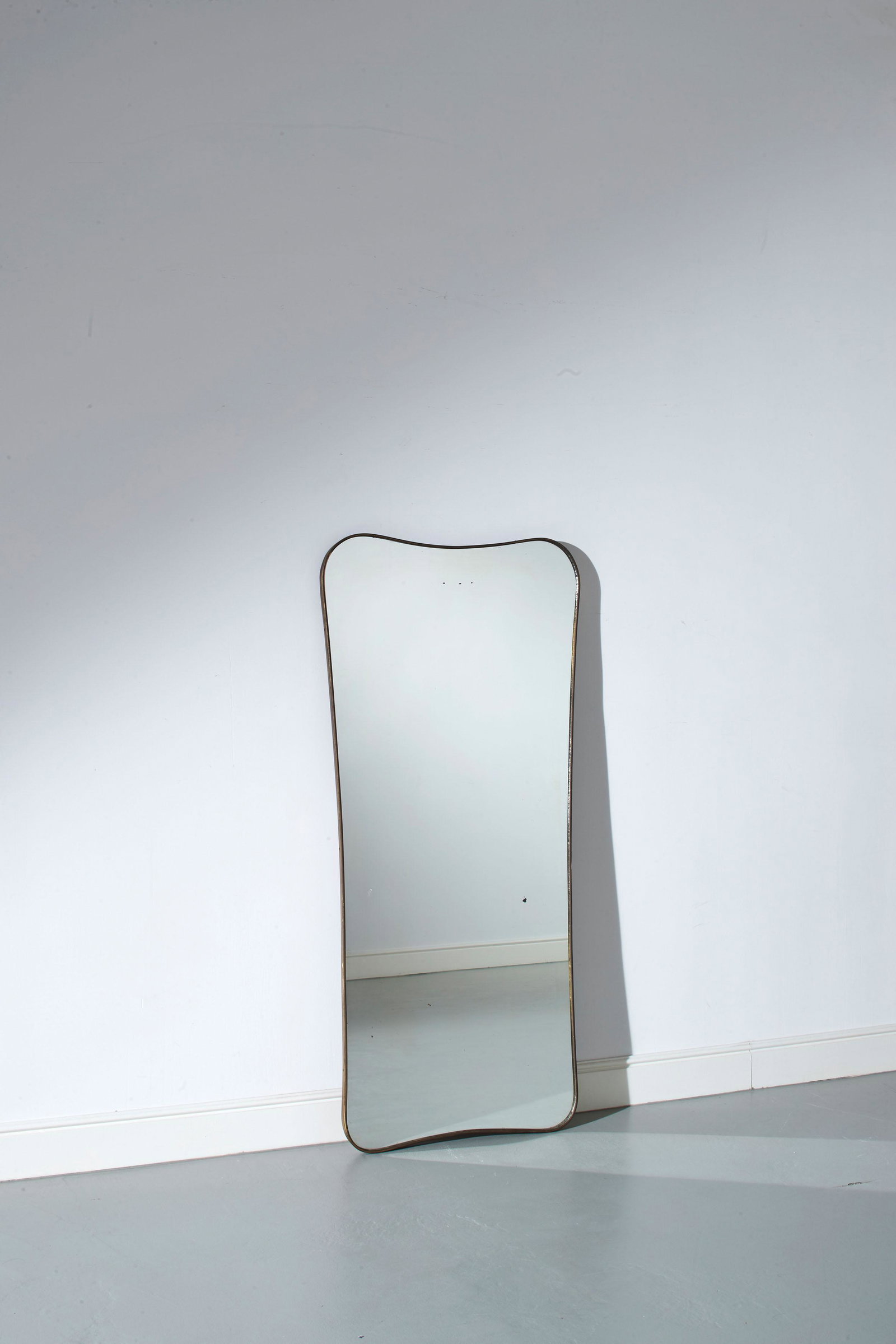 MANIFATTURA ITALIANA: Specchio. Ottone, cristallo specchiato. Italia anni '50. cm 141x66x3 AN ITALIAN MIRROR Buone condizioni generali. Piccole righe, segni di usura, lieve ossidazione. Mancanze alla specchiatura.