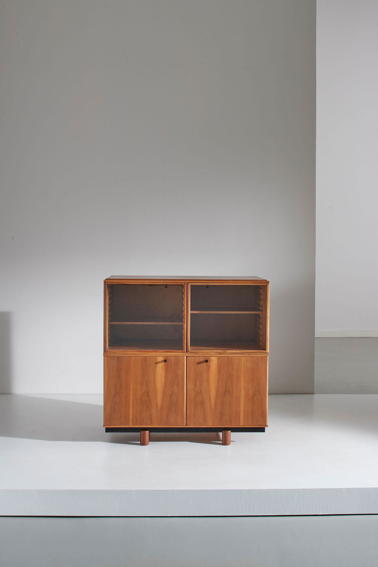 GIANFRANCO FRATTINI: Mobile contenitore della serie Ovunque. Metallo smaltato, legno lamellare impiallacciato in legno di noce, cristallo molato. Produzione Bernini anni '80. Marchio Bernini sulle presine. cm 112x110x60 A