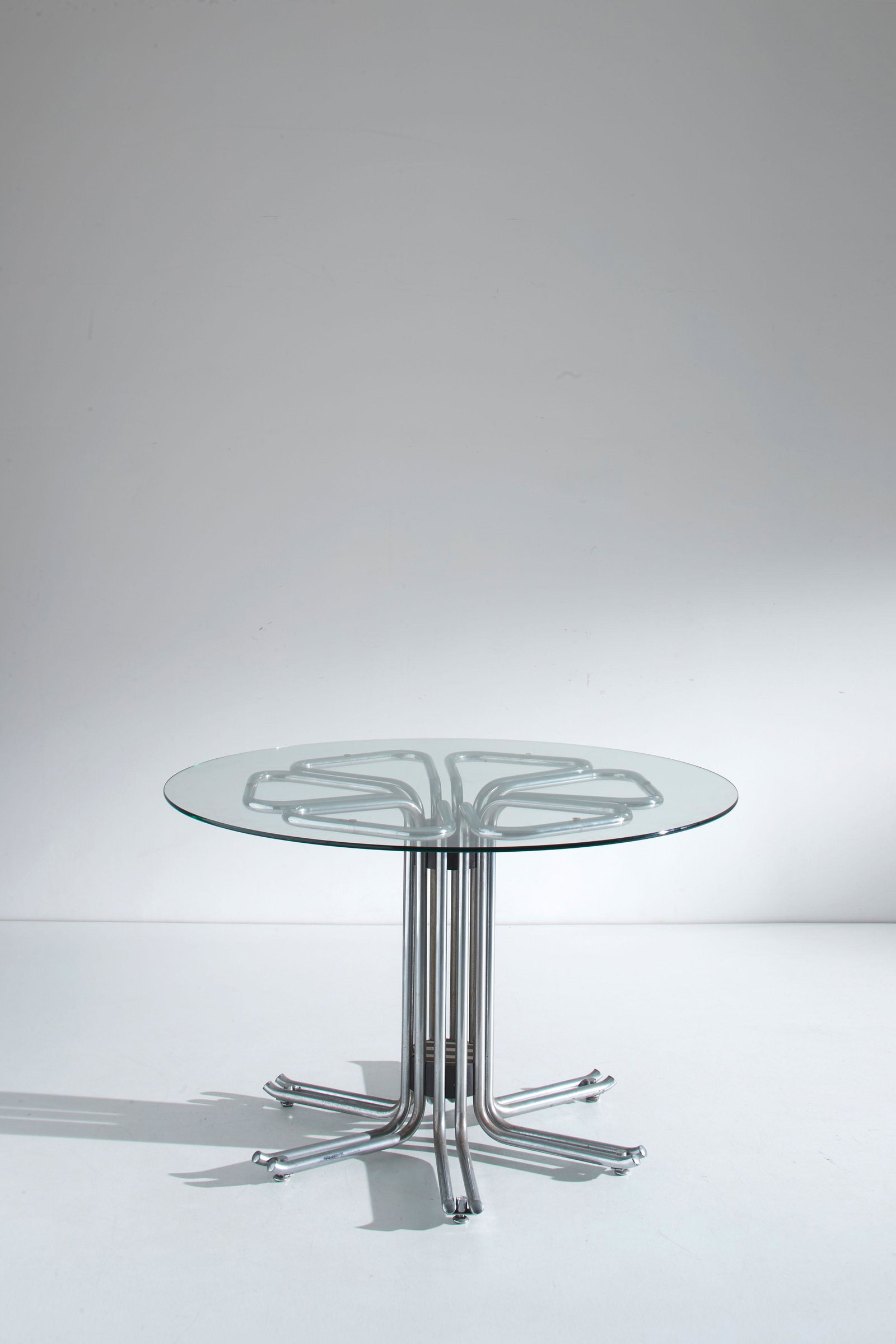 MANIFATTURA ITALIANA: Tavolo tondo. Metallo cromato, legno laccato, cristallo molato. Italia anni '70. cm 75x120 AN ITALIAN TABLE Discrete condizioni. Righe segni d'usura, ossidazione sulla cromatura.