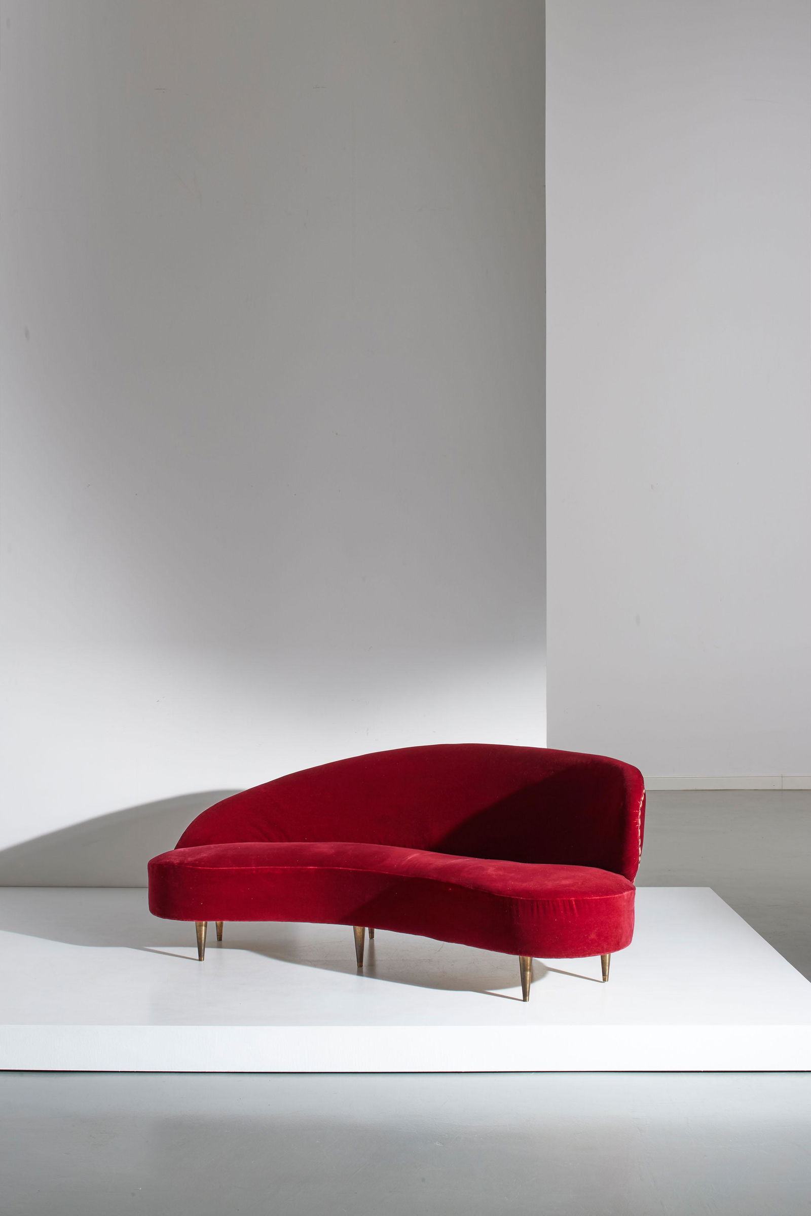 FEDERICO MUNARI: Divano curvo. Legno, ottone, velluto imbottito. Italia anni '50. cm 82x197x100 A CURVED SOFA BY F. MUNARI