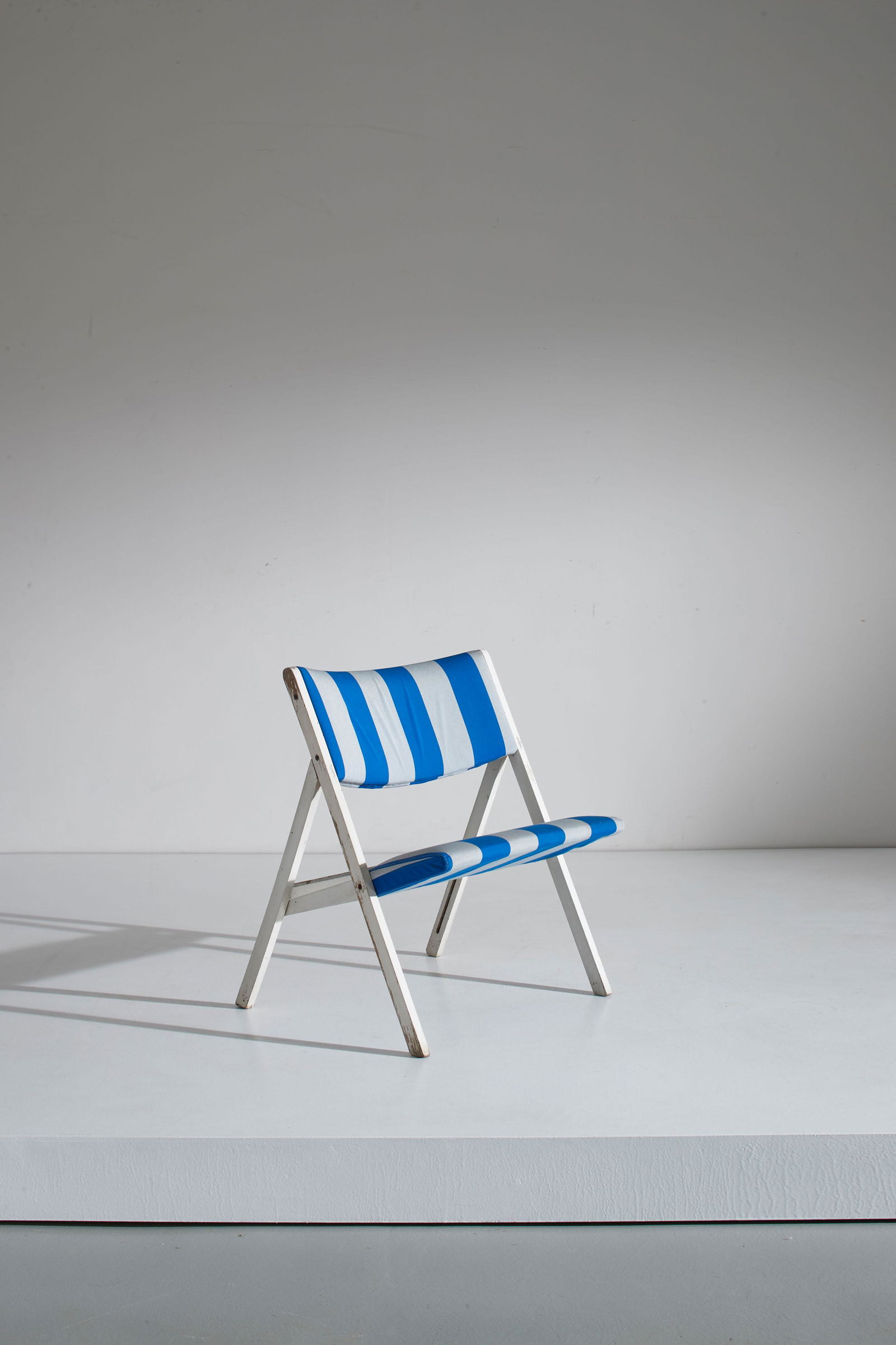 GIO PONTI: Poltroncina pieghevole. Legno di faggio laccato, tessuto imbottito. Produzione Walter Ponti, Mantova, anni '60. Etichetta della manifattura. cm 74x60x65 A LOUNGE CHAIR BY G. PONTI