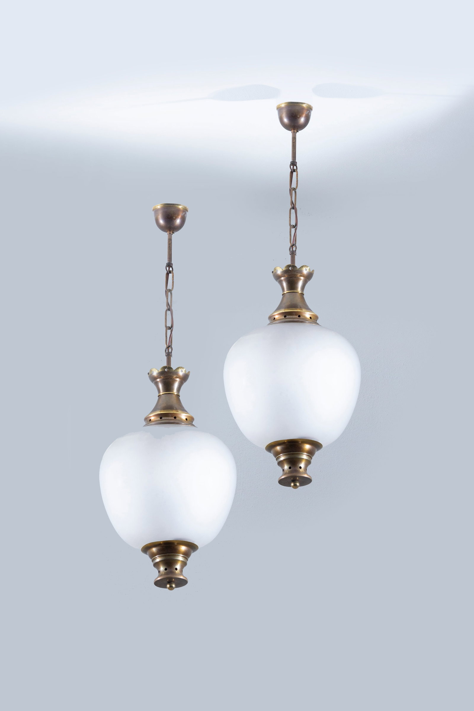 MANIFATTURA ITALIANA: Coppia di lanterne. Ottone, vetro opalino. Anni '50. cm 85x28 AN ITALIAN CEILING LAMP Condizioni generali buone. Piccole righe e segni di usura. Presente ossidazione.