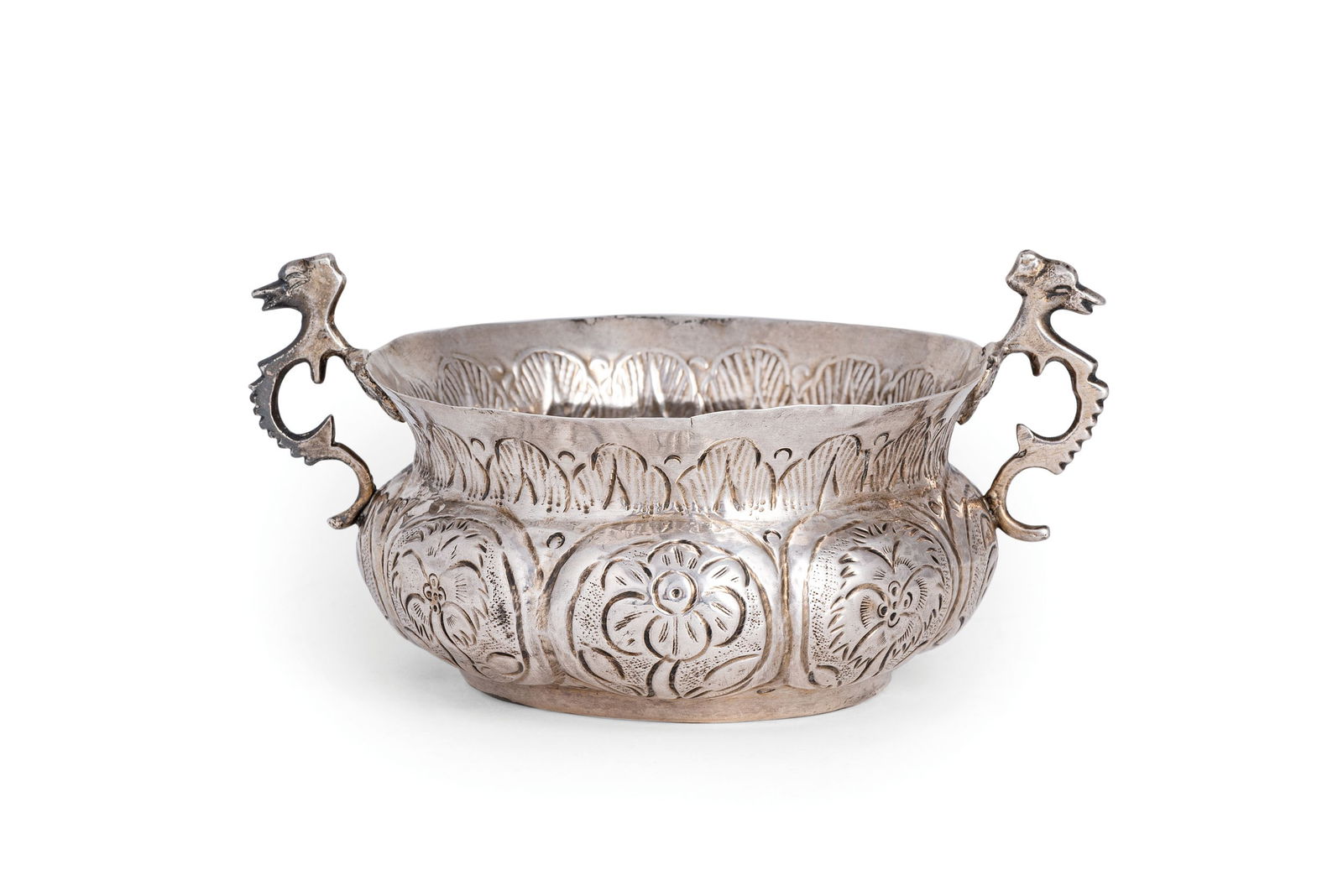 CIOTOLA A DUE MANICI IN ARGENTO, TRAPANI, XVIII SECOLO: a base circolare, corpo borchiato con elementi naturalistici, manici zoomorfi, sul bordo incisa la frase PER ELEMOSINA ALLA BAMMINA; difetti Alt. cm 7, larg. cm 13,5; peso gr 125 AN ITALIAN SILVER BOW