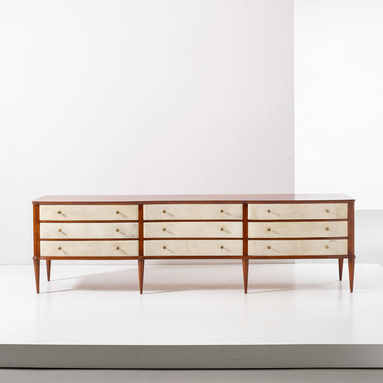 OSVALDO BORSANI: Cassettiera. Legno di mogano, ottone, pergamena. Esecuzione Arredamenti Borsani Varedo anni 50. Etichetta metallica sul retro. Certificato d'autenticità dell'Archivio Borsani. cm 75x256x54 A SIDE