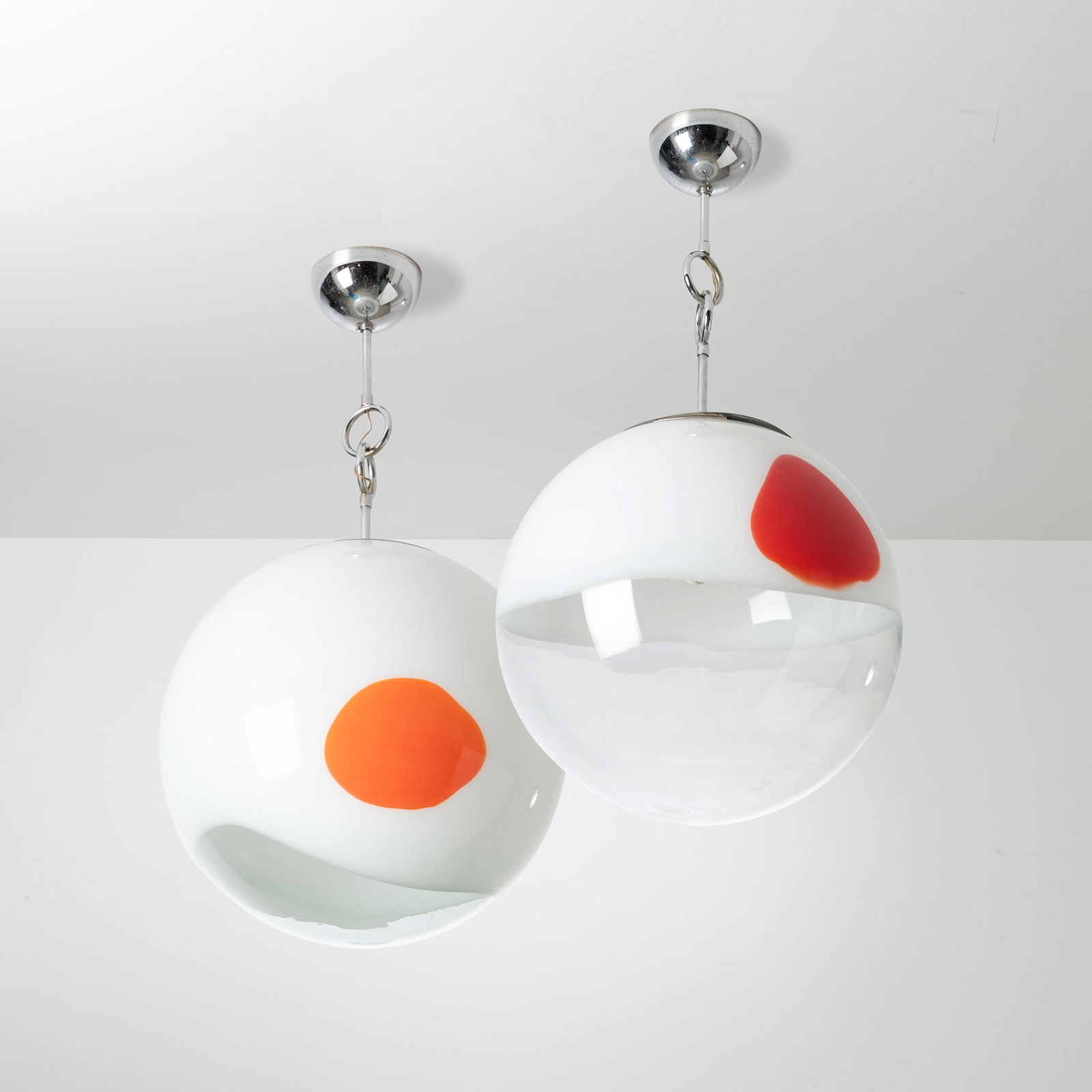 ANGELO BROTTO: Coppia di lampade a sospensione. Metallo cromato, vetro soffiato con inclusione di fascia lattimo e macchia colorata. Produzione Esperia Poggibonsi anni '60. Diametro diffusore cm 38 A PAIR OF CEILING