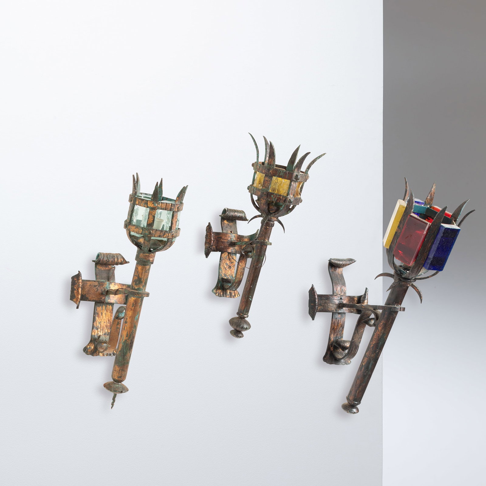 ALBANO POLI: Tre lampade da parete brutaliste. Ferro patinato, vetro massiccio. Produzione Poliarte anni '60. cm 68x23x40; cm 53x18x20 THREE WALL LIGHTS BY A. POLI Buone condizioni generali. Piccole righe, leggeri