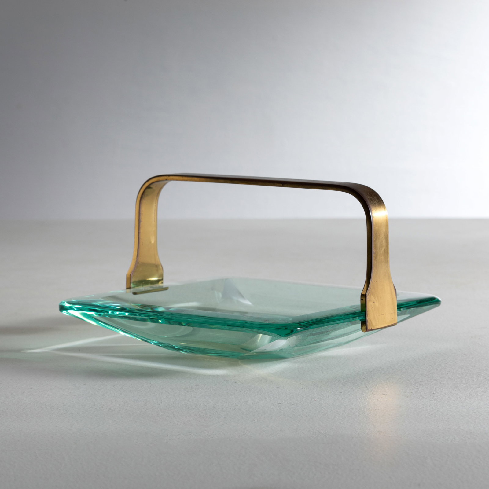 FONTANA ARTE: Svuota tasche. Ottone massiccio, cristallo colorato e molato. Italia anni '60. cm 12,5x21,5x22 A CENTERPIECE BY FONTANA ARTE Condizioni molto buone. Segni di usura. Piccole righe, ossidazione.