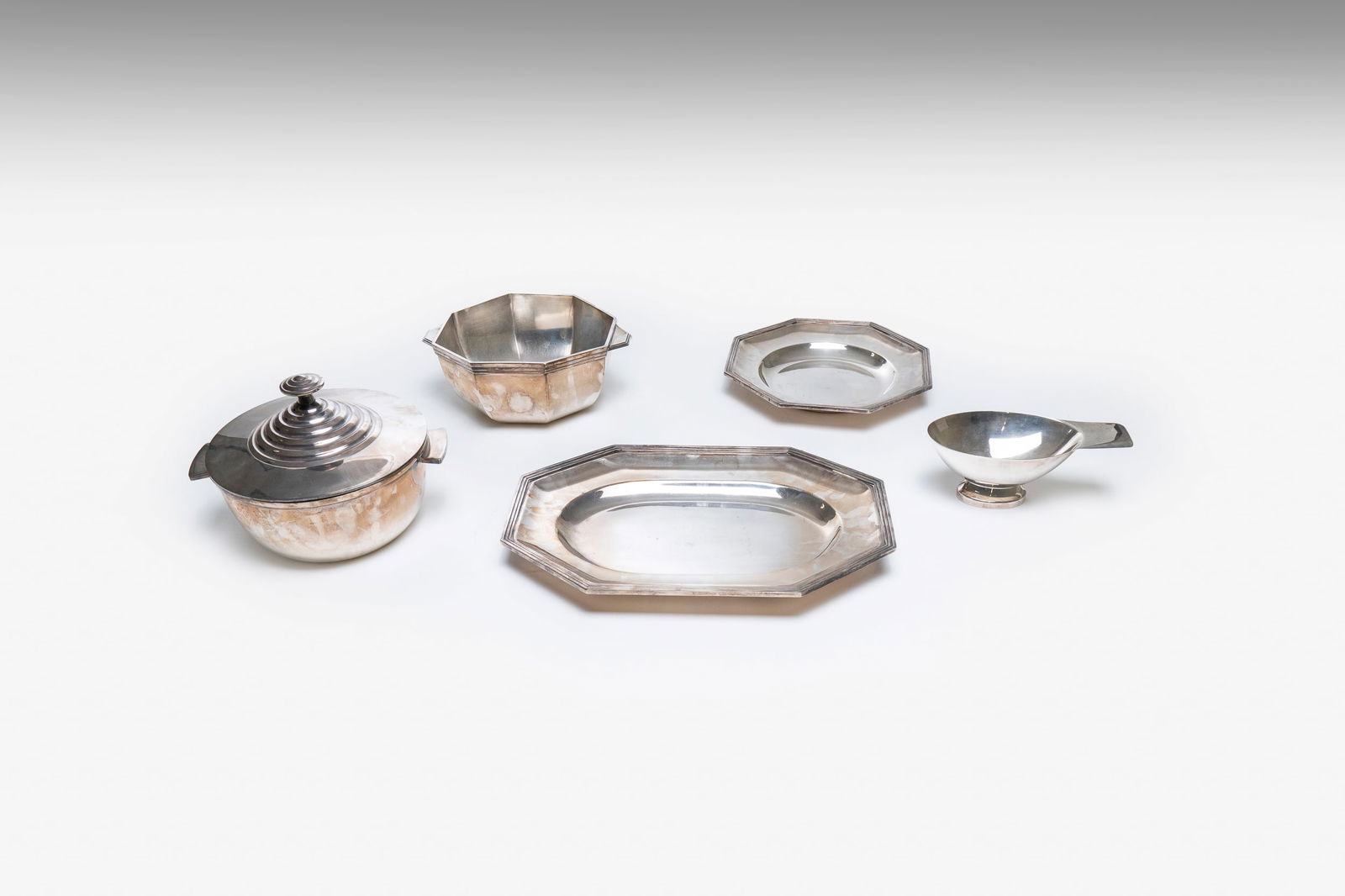 CHRISTOFLE: Set da tavolo, struttura in metallo argentato. Marchio incusso. Prod. Christofle, Francia, 1950 circa. ciotola con coperchio 13 x 27 x 23 cm, ottagonale 7 x 27 x 21 cm, vassoio 3 x 27 x 27, ciotolina