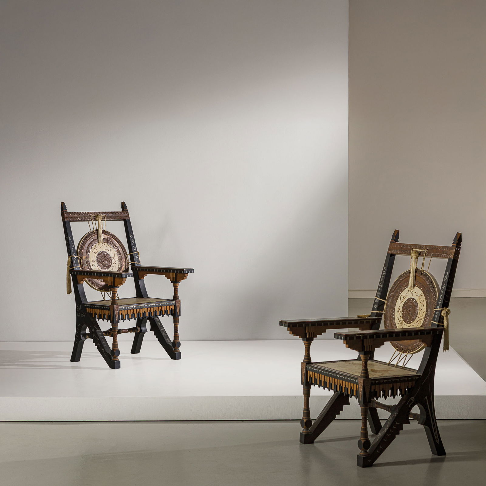CARLO BUGATTI: Due poltrone. Legno di noce, legno ebanizzato, legno di frutto, osso, peltro, ottone, pergamena dipinta, rame sbalzato. Atelier dell'Artista, Parigi, 1900 ca. cm 118x67x76 Le due poltrone vengono esit