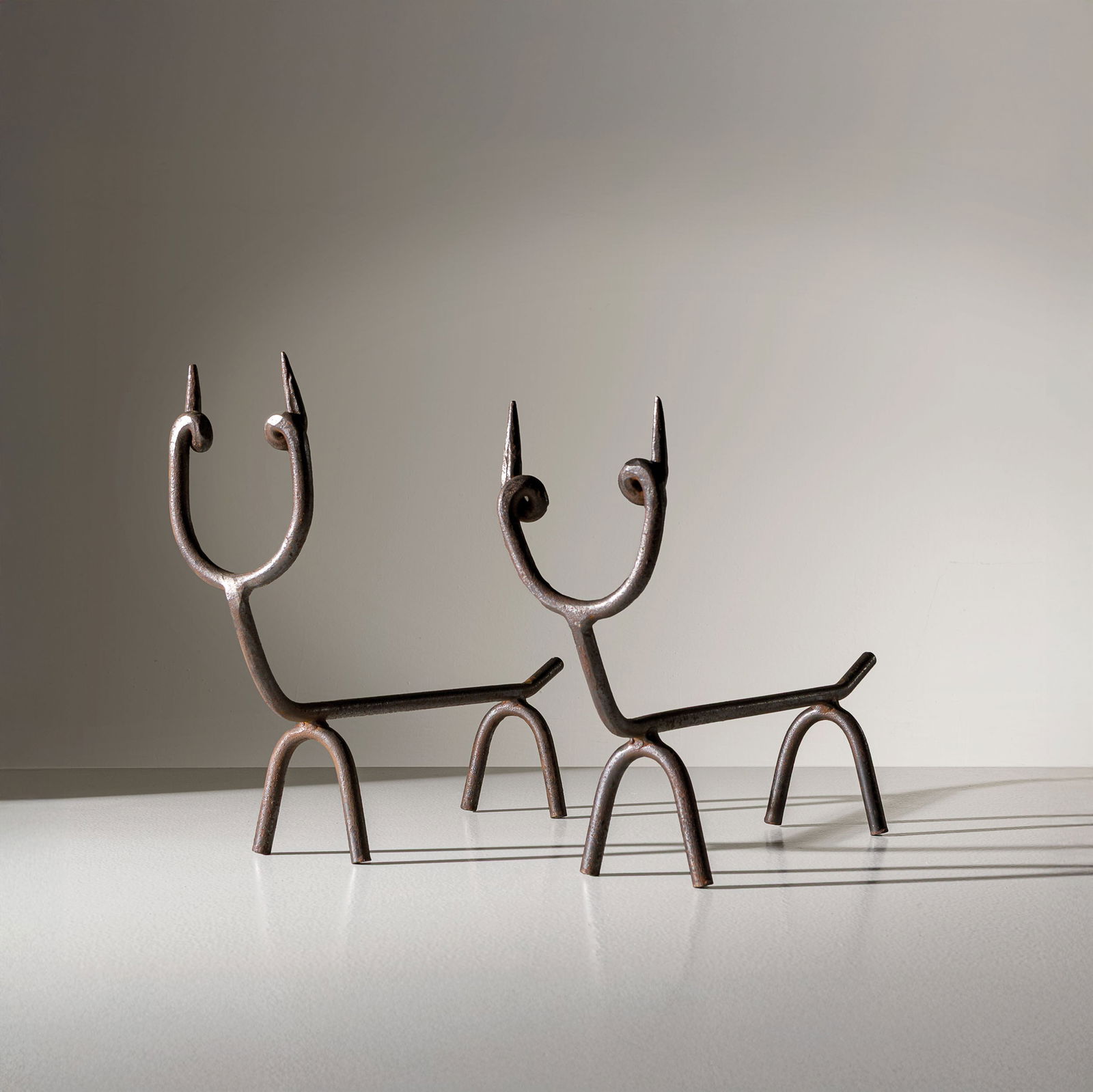 GIO PONTI: Coppia di alari da camino. Ferro forgiato. Italia, anni '50. Perizia Gio Ponti Archives. cm 40x13,5x56 A PAIR OF FIRE WINGS BY G. PONTI Buone condizioni. Tracce di ruggine, ossidazione diffusa.