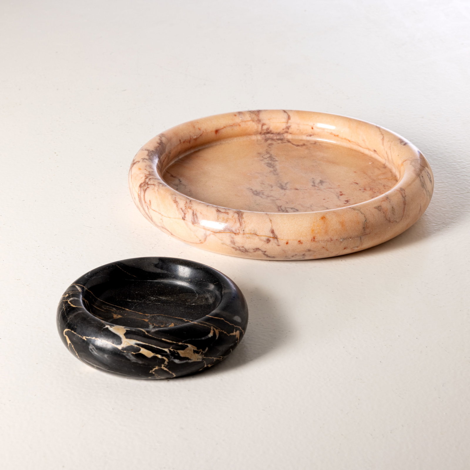 UP & UP: Due svuotatasche. Marmo rosa partogallo e Portoro torniti. Italia anni '60. cm 4x16; cm 5x30 TWO MARBLE BOWLS BY UP & UP Buone condizioni generali. Piccoli graffi e leggeri segni di usura dovuti all'u