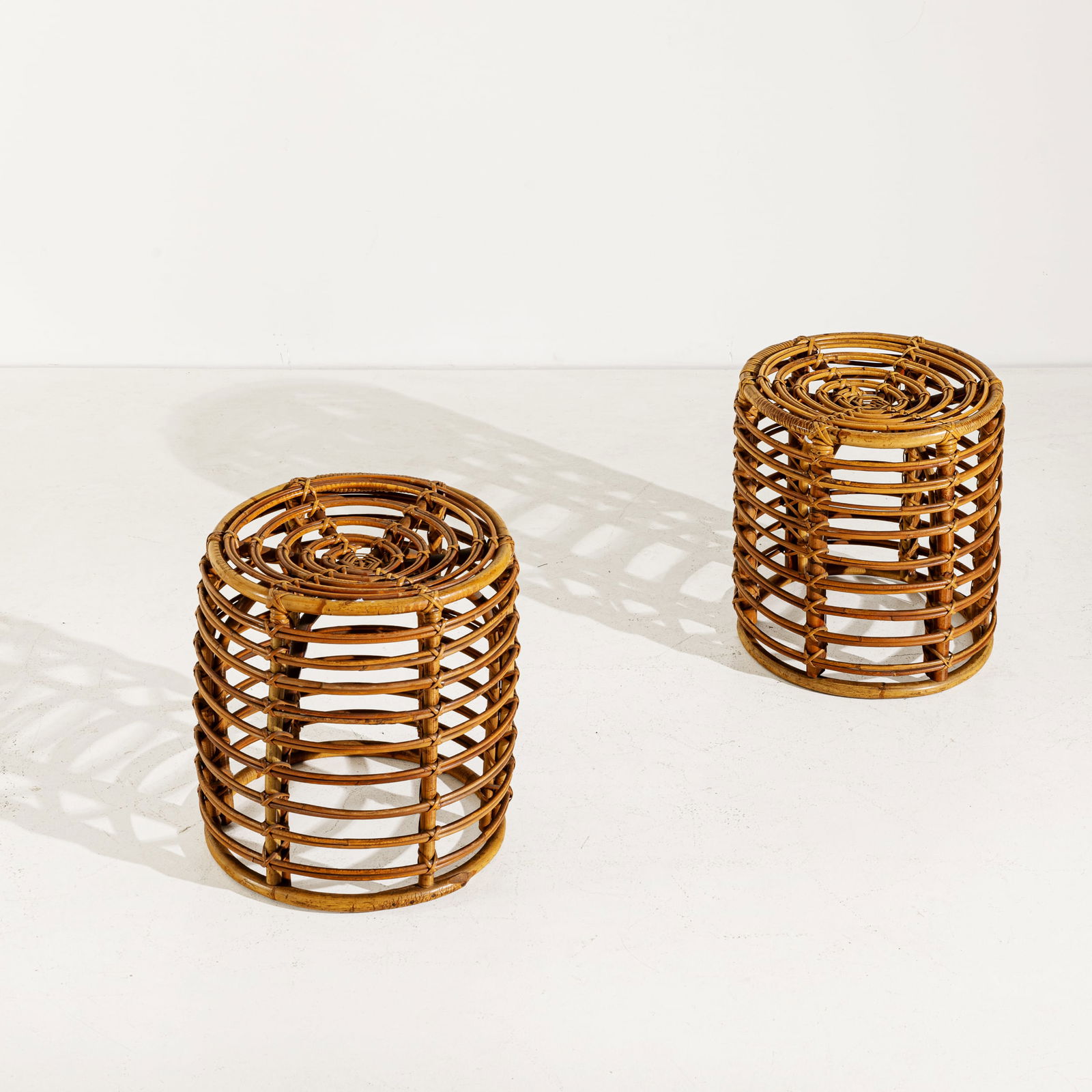 TITO AGNOLI: Due sgabelli. Canna d'India, tessuto imbottito. Italia anni '60. cm 40x38 TWO OTTOMANS BY T. AGNOLI Buone condizioni generali. Piccole righe, leggeri graffi, normali segni di usura. Ossidazione alla v