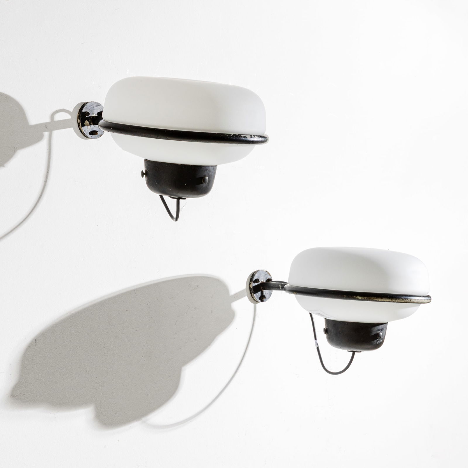 GINO SARFATTI: Coppia di lampade da parete mod. 228/E. Metallo v erniciato, vetro opalino satinato. Produzione Arteluce, 1957. cm 16x25x35 A PAIR OF WALL LAMPS BY G. SARFATTI M. Romanelli, S. Severi, Gino Sarfatti o