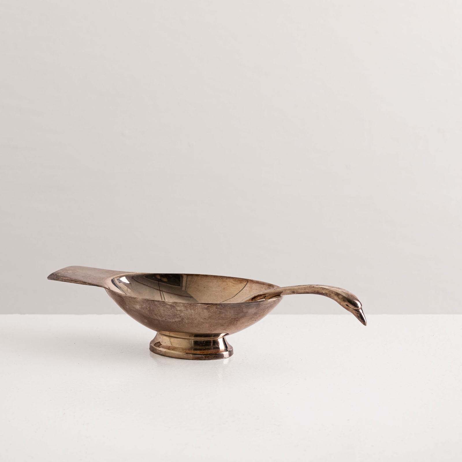CHRISTIAN FJERDINGSTAD: Salsiera. Metallo argentato. Marchio incusso. Produzione Christofle, anni '30. cm 8x30x10 A SAUCE/GRAVY BOAT AND LADLE BY C. FJERDINGSTAD Buone condizioni generali. Piccole righe, leggeri graffi, segn