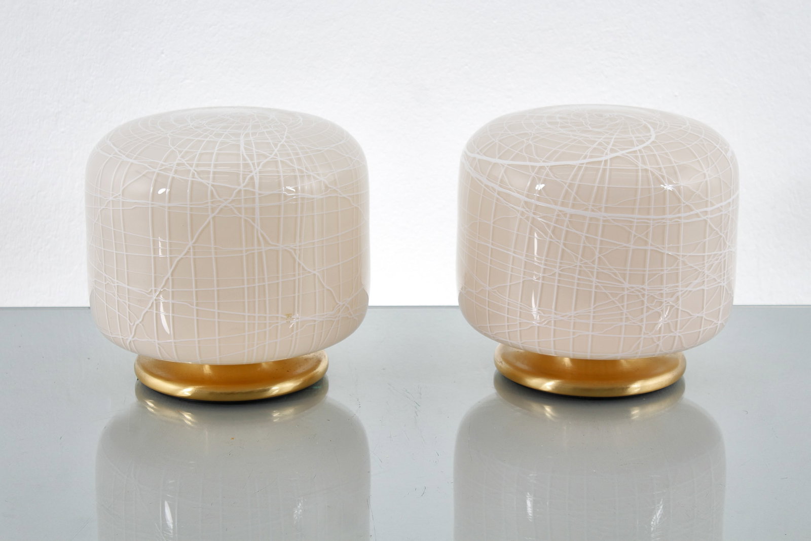 LA MURRINA: Coppia di lampade da tavolo. Vetro di Murano incamiciato, linee in vetro lattimo, metallo dorato, plastica. Italia anni '80. Monogramma in vetro del produttore. cm 20xØ20 TWO TABLE LAMPS BY LA MU