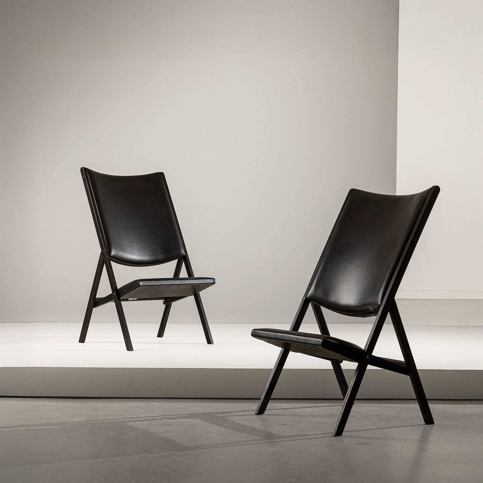 GIO PONTI: Coppia di sedie pieghevoli mod. Gabriela della serie Apta. Legno laccato, vinilpelle imbottita. Produzione Walter Ponti 1971 ca. cm 106x60x70 A PAIR OF FOLDING ARMCHAIRS BY G. PONTI Domus n. 510, magg