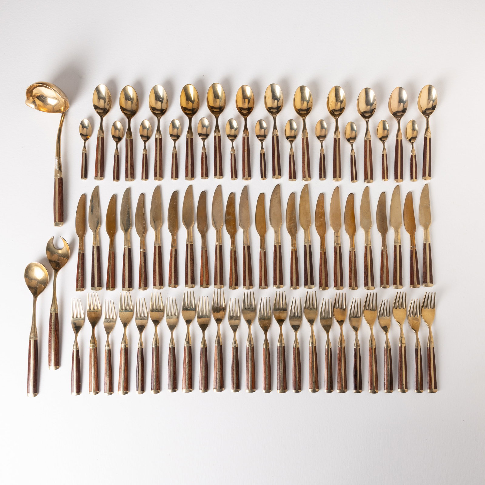 MANIFATTURA ITALIANA: Servizio di posate. Legno esotico, ottone. Italia anni '60. misura massima 25x4,5; misura minima 12,5x3 AN ITALIAN FLATWARE Buone condizioni generali. Piccole righe, leggeri graffi, normali segni di u