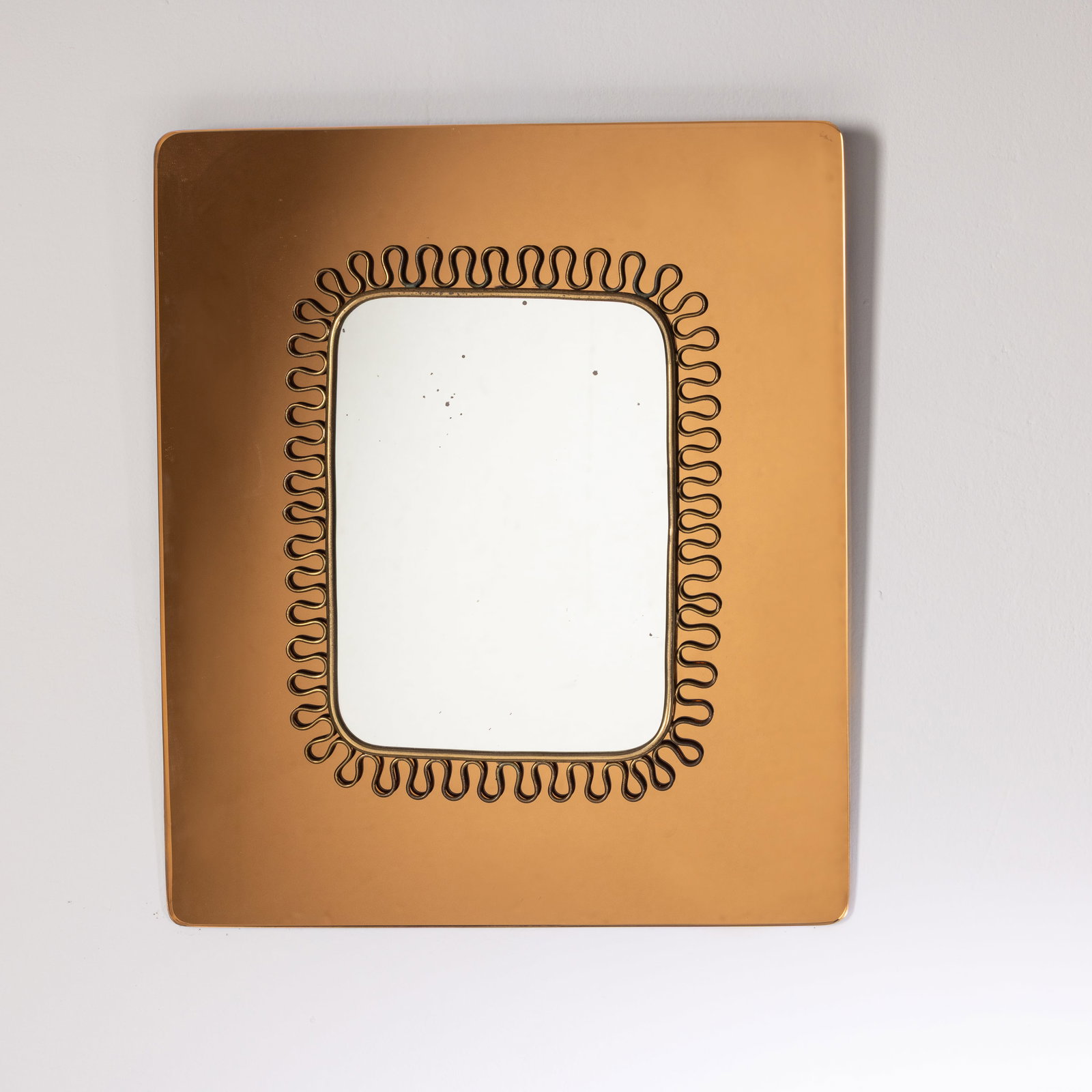 GIO PONTI (ATTRIB. A ): Specchio da parete. Ottone, vetro specchiato. Italia anni '50. cm 36x42 A MIRROR ATTRIBUTED TO G. PONTI Buone condizioni. Righe, segni di usura, ossidazione. Piccole mancanze e lieve ossidazione alla
