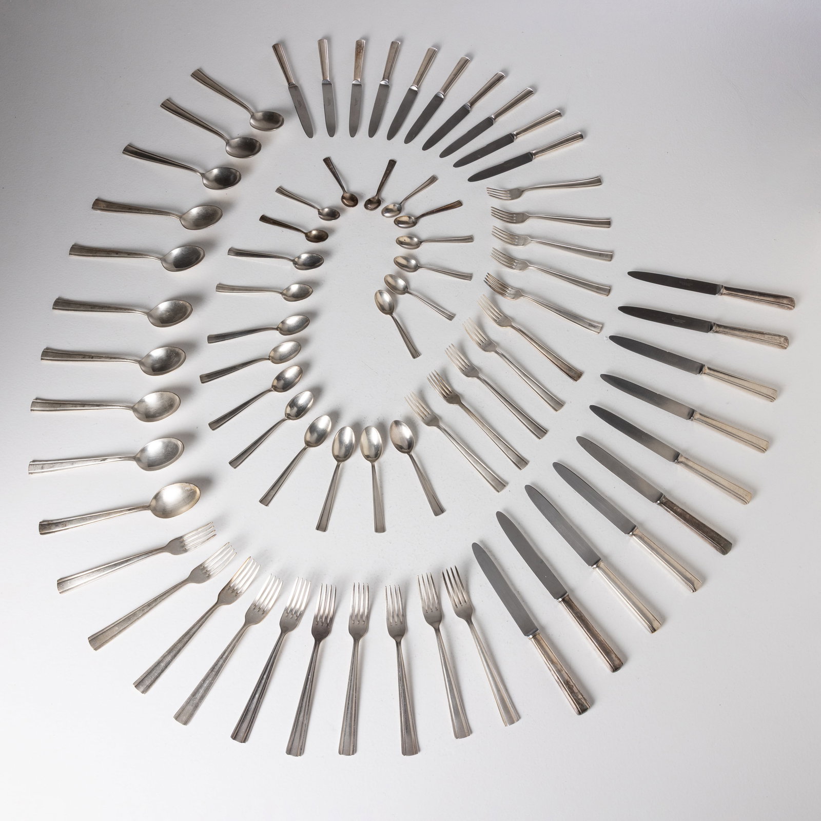 GIO PONTI: Servizio di posate. 70 pezzi. Metallo argentato. Produzione Krupp, anni '30-'40. Marchio impresso. coltello grande cm 26x2x1; coltello piccolo cm 21x2x1; forchetta grande 21x2,5x1; forchetta