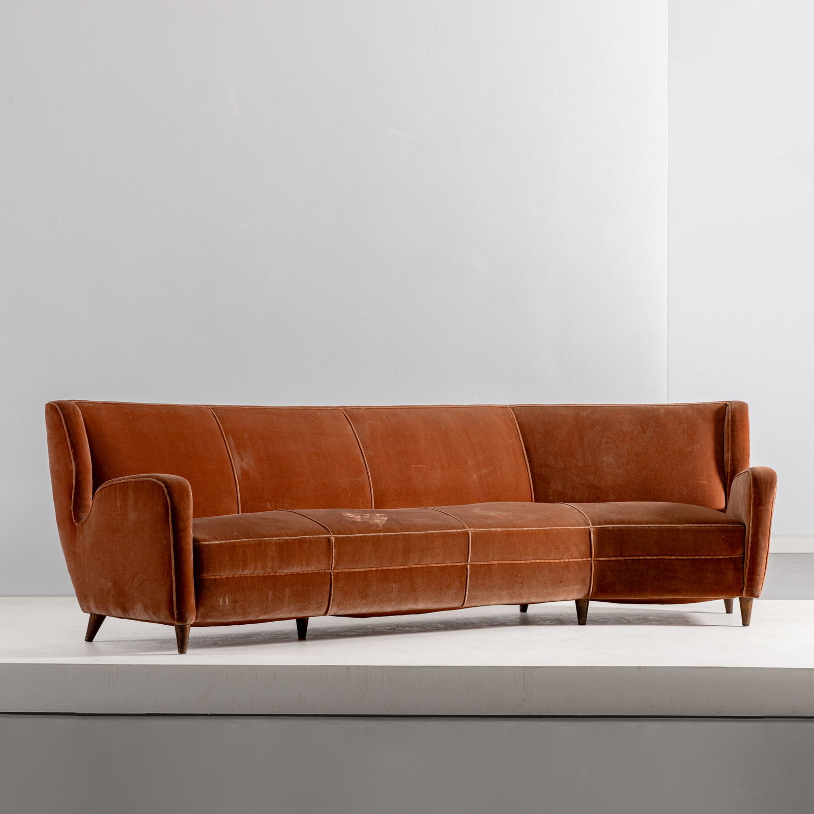 GIO PONTI (ATTRIB A): Grande divano. Legno di noce, tessuto imbottito. Probabile esecuzione Cassina, anni '50. cm 80x270x110 ca. A CURVED SOFA ATTRIBUTED TO G. PONTI