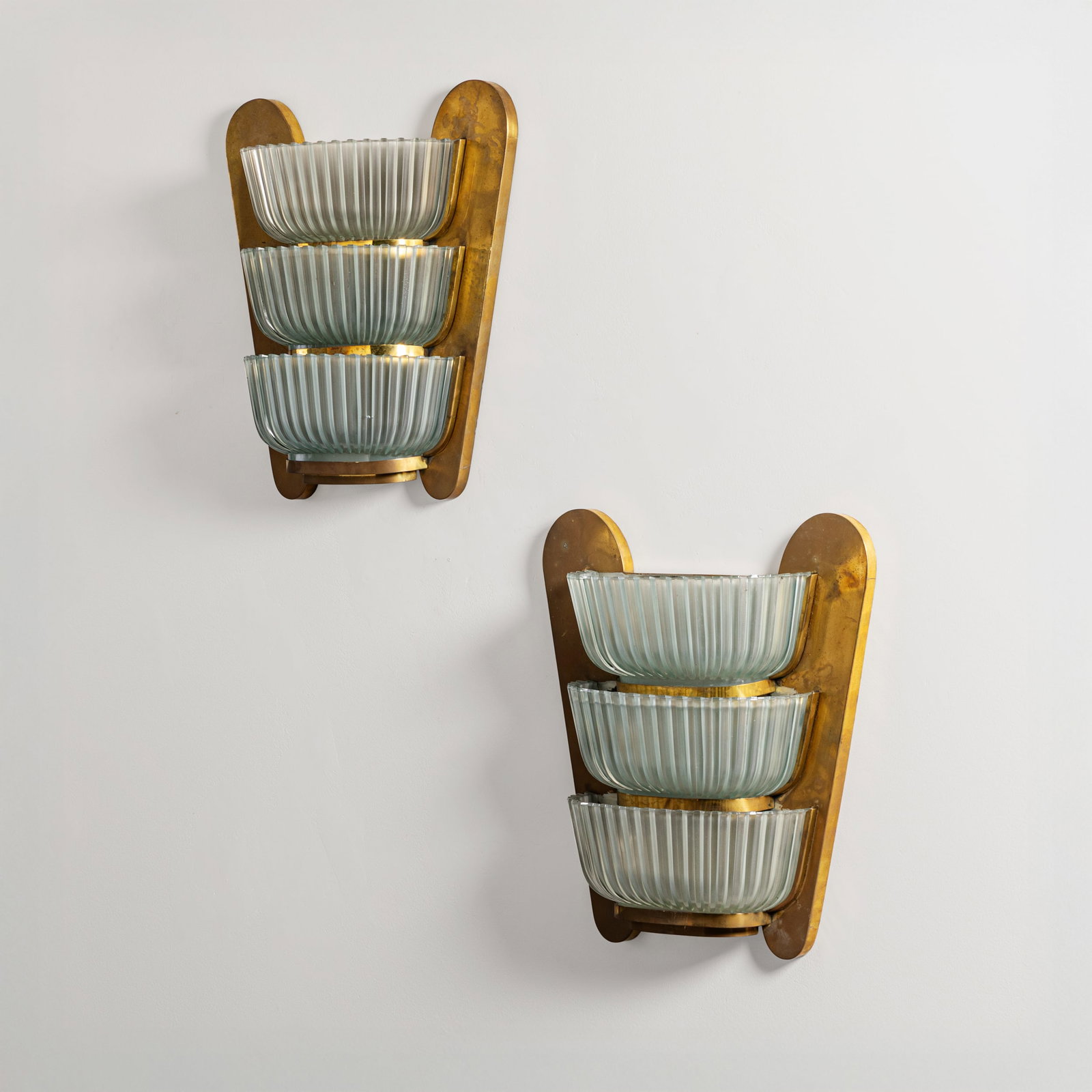 ARCHIMEDE SEGUSO: Coppia di lampade da parete. Ottone, vetro stampato. Produzione Seguso Vetri d'Arte anni '50. cm 50x45x15 A PAIR OF WALL LIGHTS BY A. SEGUSO Buone condizioni generali. Piccole righe, leggeri graffi, n