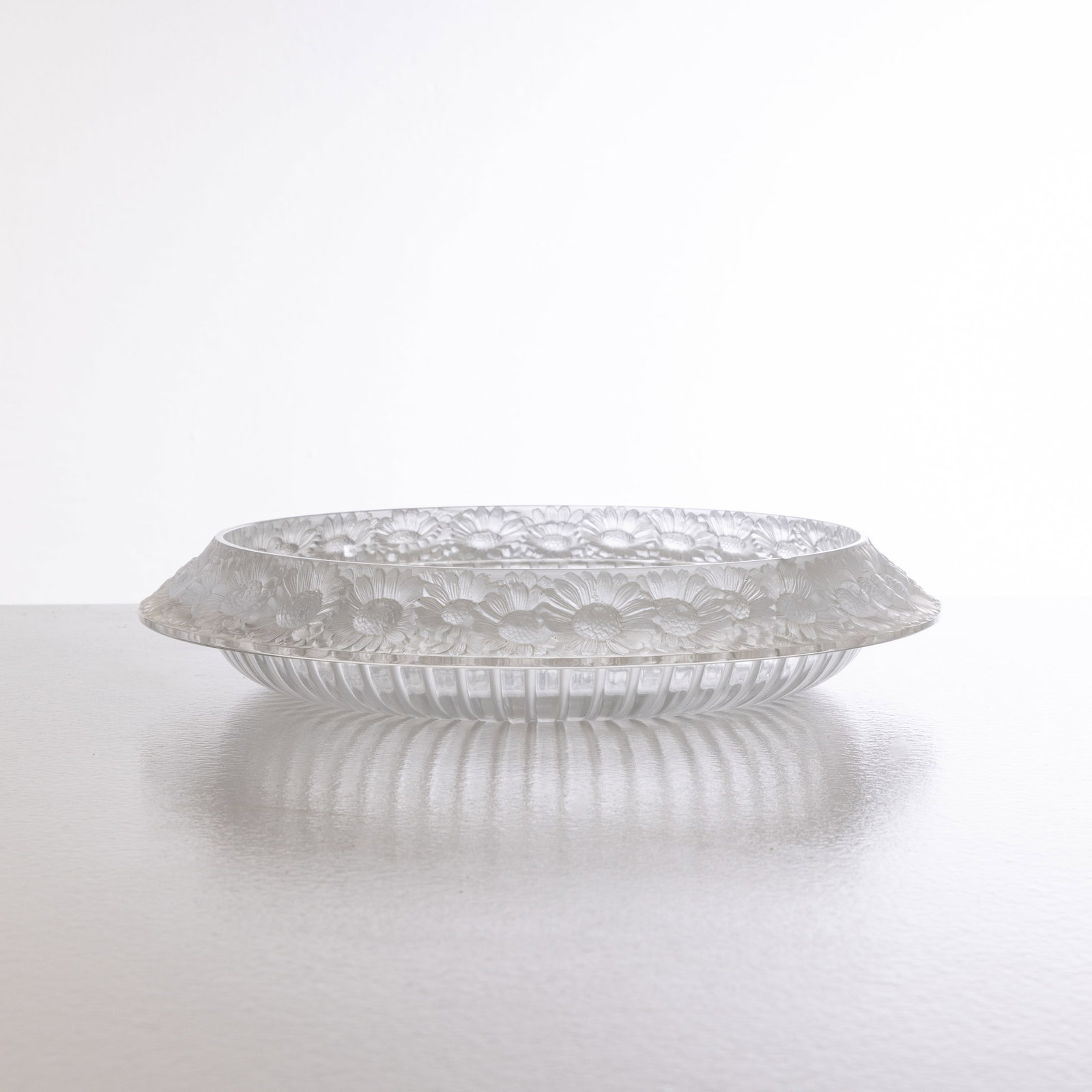 RENE' LALIQUE: Centrotavola. Cristallo con bordo decorato a rilievo a motivo floreale. Francia, primi '900. Firma incisa. cm 8x35 A CENTERPIECE BY R. LALIQUE in cristallo con bordo decorato a rilievo a motivo