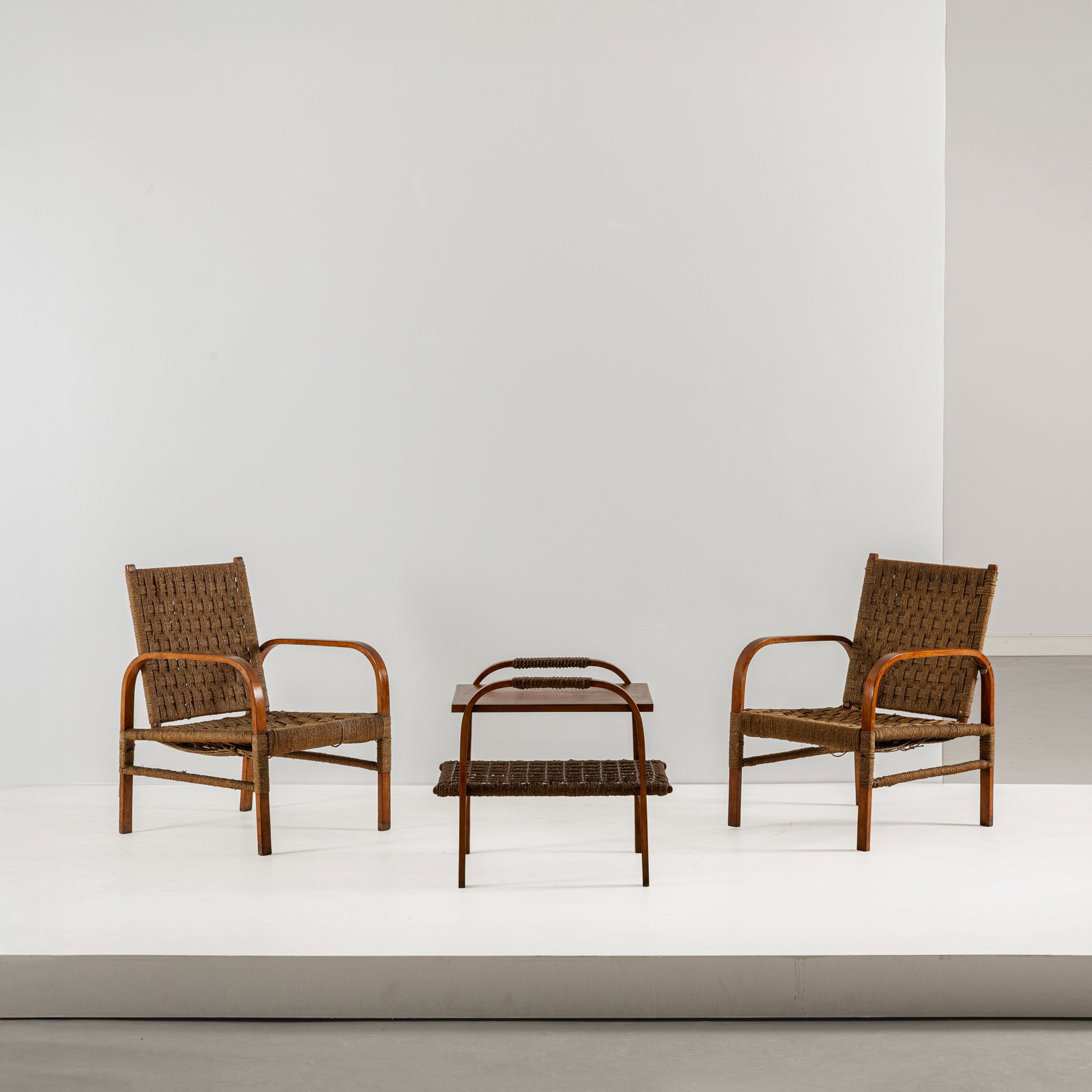 MANIFATTURA ITALIANA: Coppia di poltrone ed un tavolino. Multistrato curvato impiallacciato in legno di noce, paglia di fiume intrecciata. Italia anni '40. poltrone cm 80x56x64 tavolino cm 56x62x52 A APIR OF ITALIAN ARMCHA