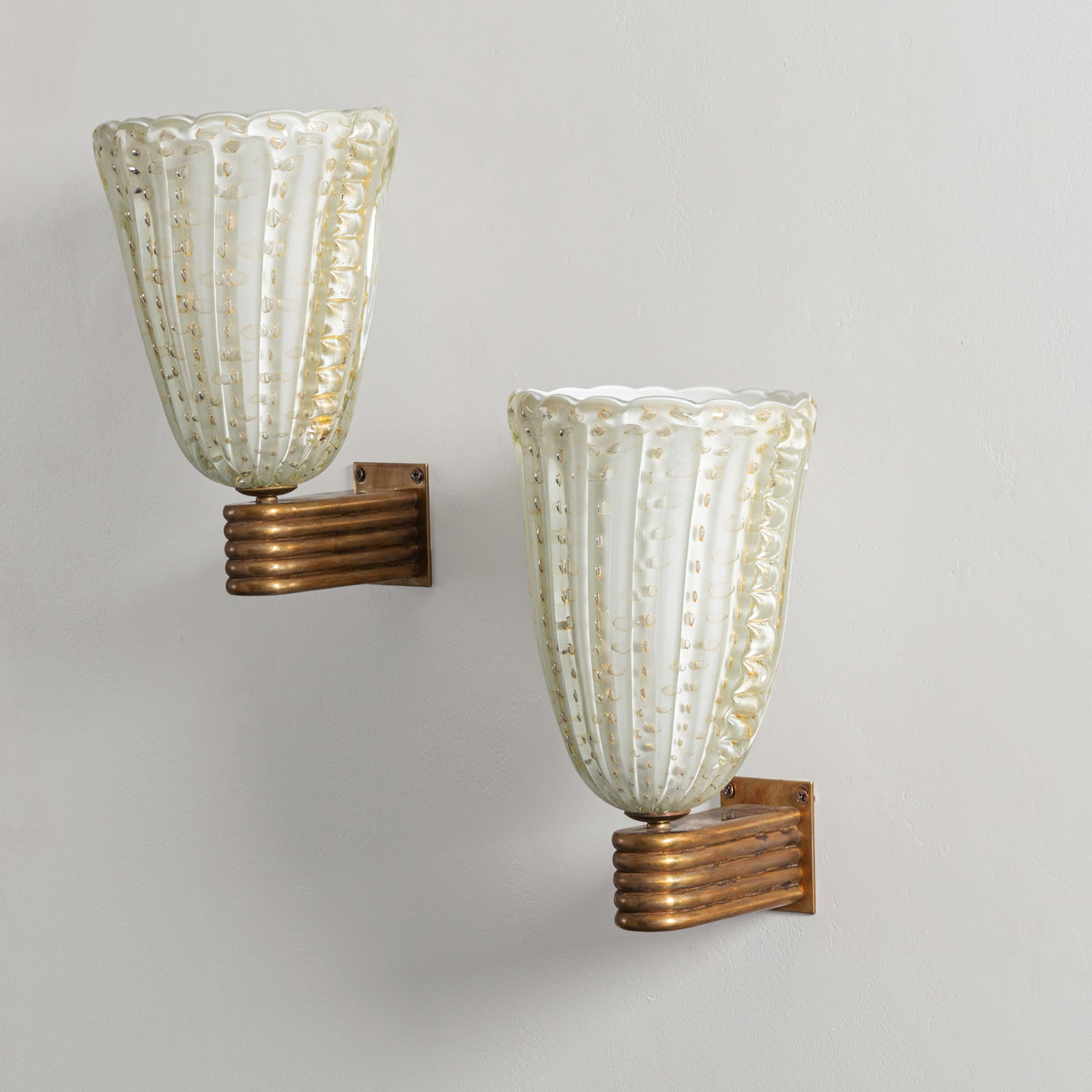 ARCHIMEDE SEGUSO: Coppia di lampade da parete. Ottone, vetro lavorato a caldo. Produzione Seguso Vetri d'Arte anni '40. cm 28x21x22 A PAIR OF WALL LIGHTS BY A. SEGUSO Buone condizioni generali. Piccole righe, leggeri g