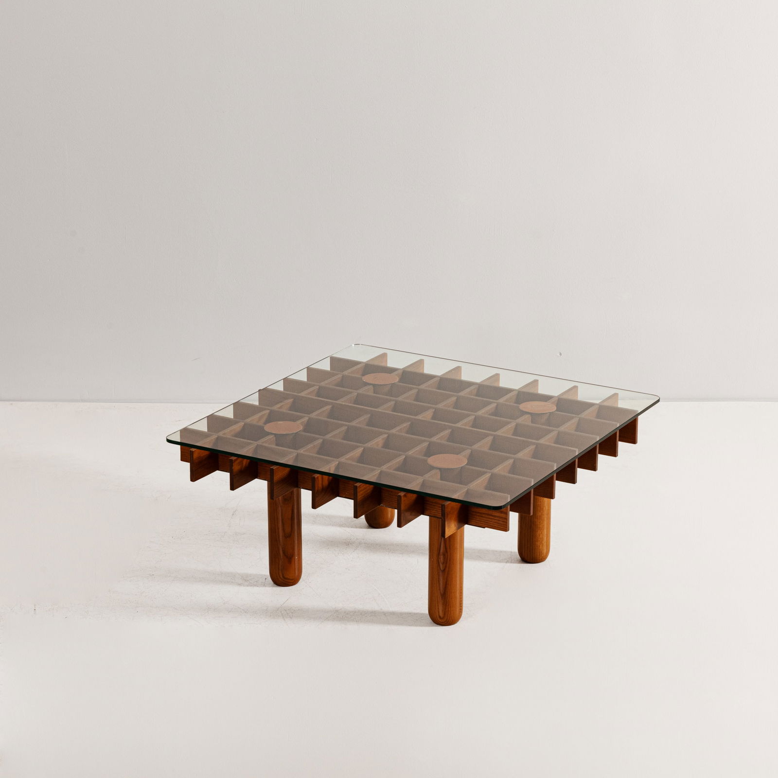 MANIFATTURA ITALIANA: Tavolino basso. Legno di frassino tornito, cristallo molato. Italia anni '70. cm 34x76x76 AN ITALIAN LOW TABLE Buone condizioni generali. Leggeri graffi sul cristallo. Lucidatura della struttura in le