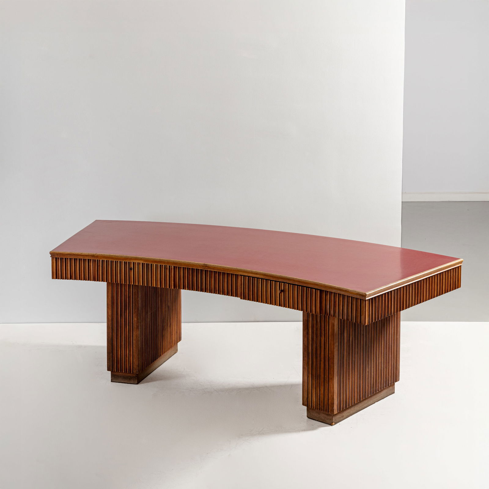 OSVALDO BORSANI: Scrivania. Legno di noce biondo, cristallo retro dipinto molato. Italia fine anni '40, etichetta metallica della manifattura. cm 82x200x90 ca. A DESK BY O. BORSANI Condizioni molto buone.