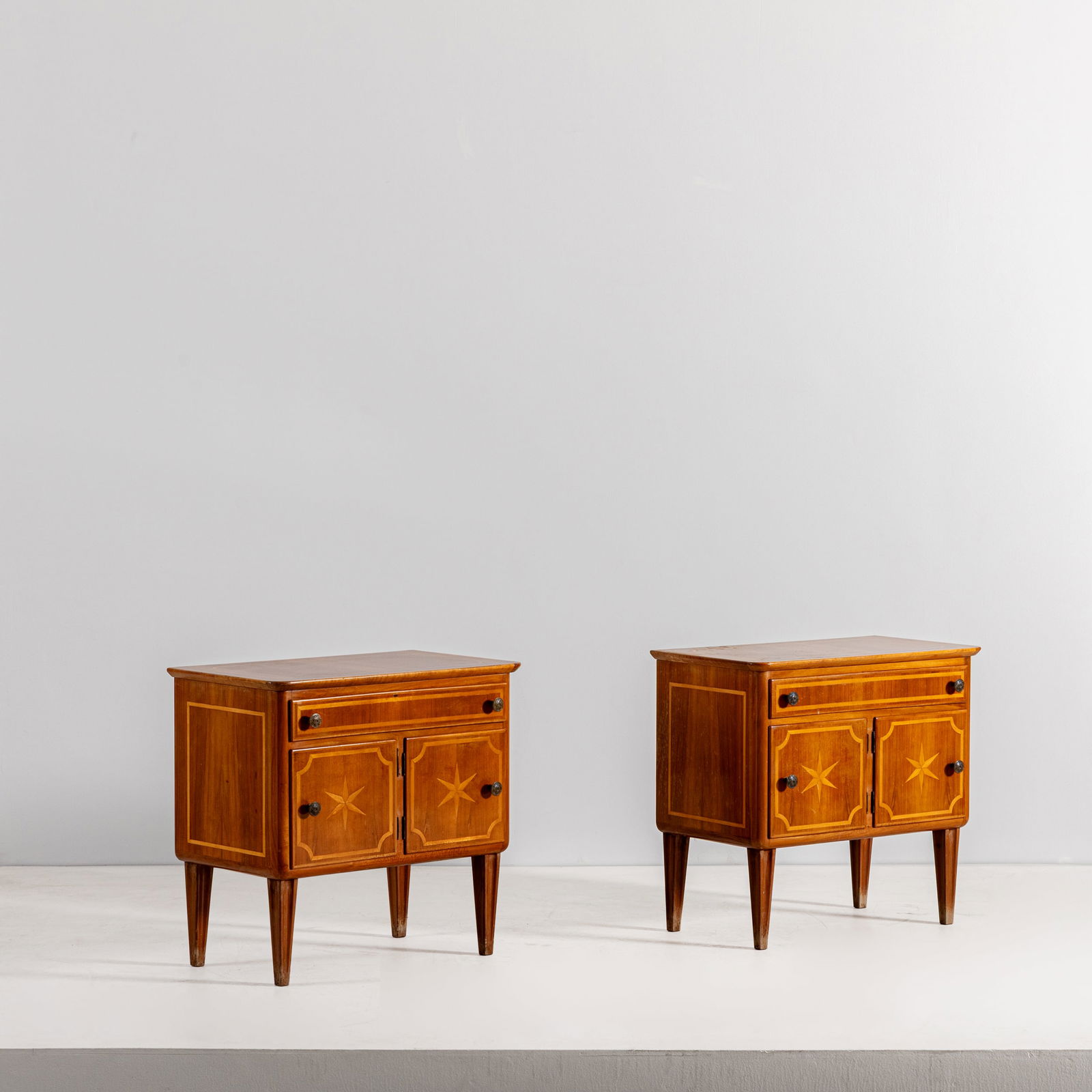 MARIO CEREGHINI: Coppia di comodini. Legno di noce, ottone, marqueterie in legno di noce chiaro. Italia anni '40. cm 69x72x43 A PAIR OF BEDISDE TABLES BY M. CEREGHIN Buone condizioni generali. Piccole righe,