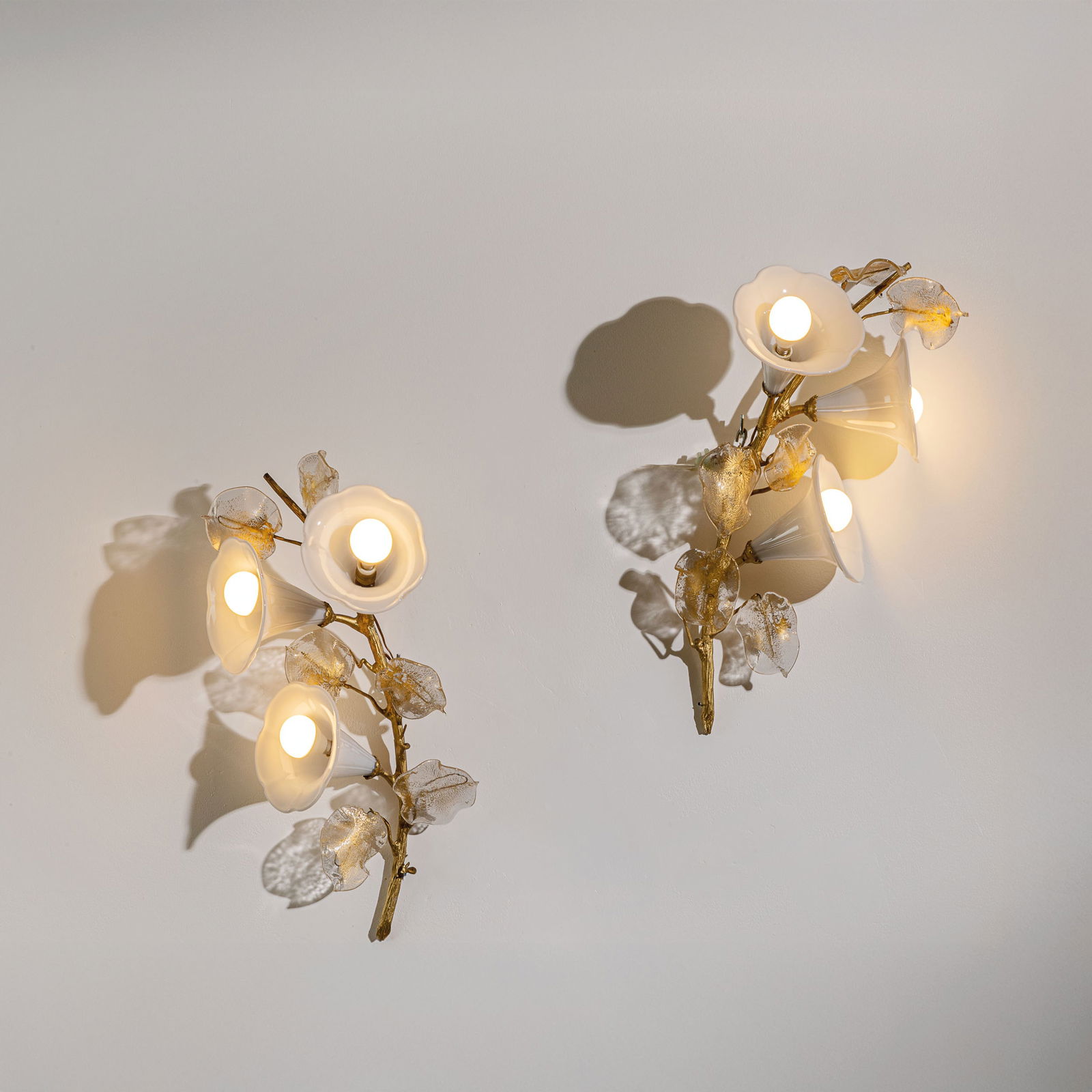 VENINI: Coppia di lampade da parete. Metallo dorato, vetro lavorato a caldo. Produzione Venini, anni '40. cm 50x30x21 A PAIR OF WALL LAMPS BY VENINI Buone condizioni generali. Piccole righe, leggeri