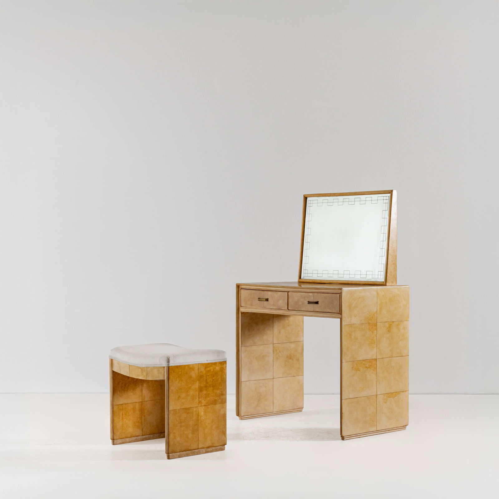 MANIFATTURA ITALIANA: Toelette con sgabello. Legno rivestito in pergamena, cristallo specchiato, ottone. Italia anni '40. toeletta cm 124x86x48; sgabello cm 47x51x34 AN ITALIAN VANITY WITH STOOL Buone condizioni