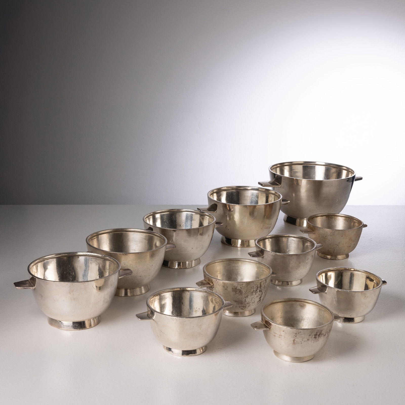 GIO PONTI: Undici ciotole di diverse dimensioni. Metallo argentato. Produzione F.lli Calderoni anni '30. cm 15,5x34x26; cm 11,5x24x17,5; cm 8,5x18x13,5 ELEVEN BOWLS BY G. PONTI Domus, n. 143, novembre 1939, p. 4