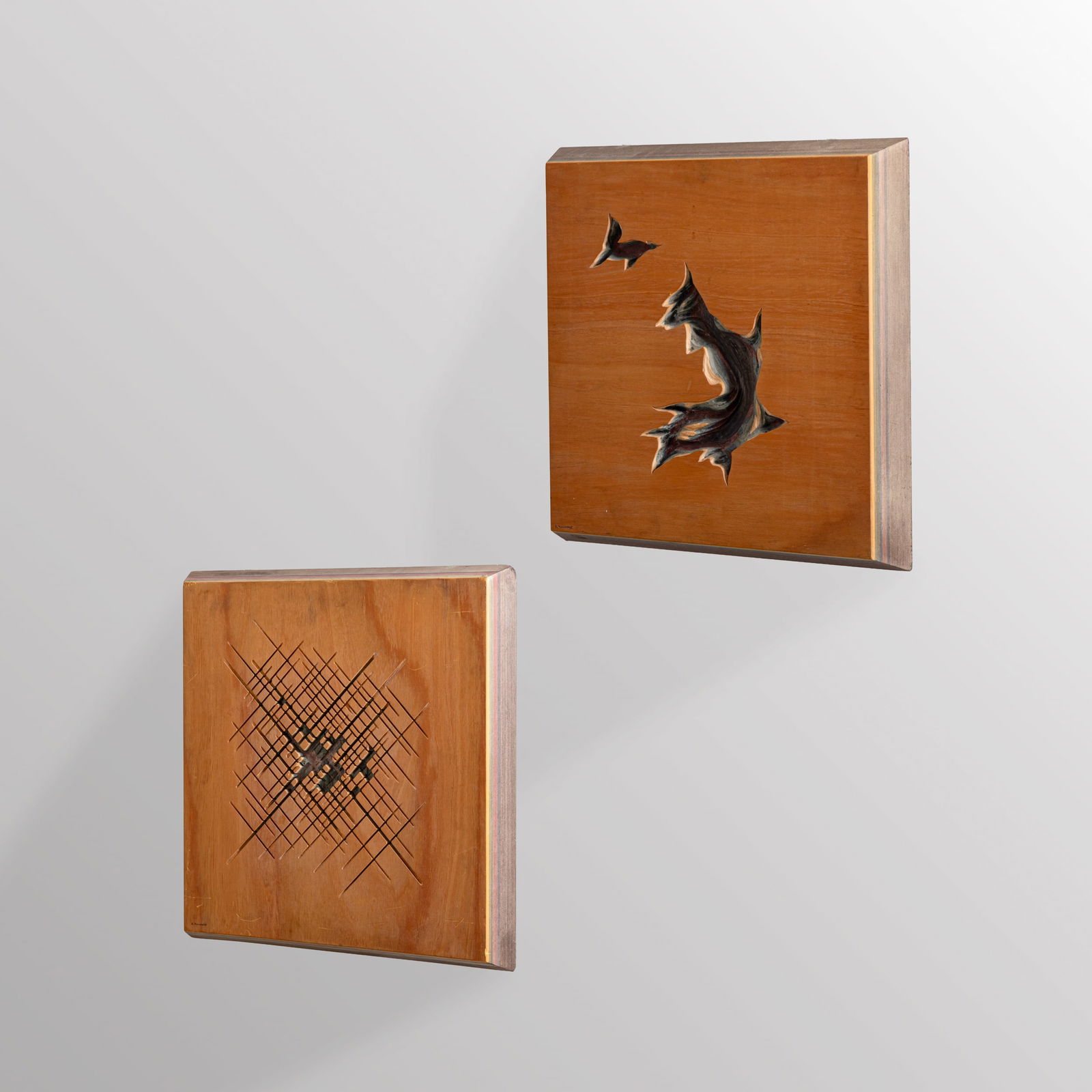 ANGELO MANGIAROTTI: Due pannelli decorativi. Multistrato tinto all'anilina, legno di noce. Produzione Arquati 1990. Firma e marchio della produzione pirografati. cm 53x53x6,5; cm 57x57x5,5 A PAIR OF PANELS BY A.