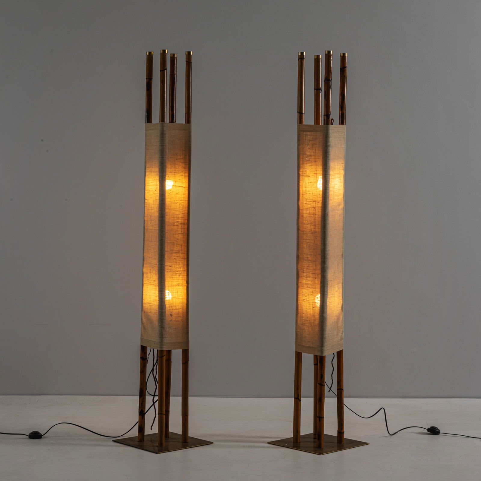 MANIFATTURA ITALIANA: Due Lampade terra. Bamboo, tessuto di canapa, ottone. Italia anni '80 cm 188x35,5x35 A PAIR OF ITALIAN FLOOR LAMPS Buone condizioni generali. Piccole righe, leggeri graffi, normali segni dovuti