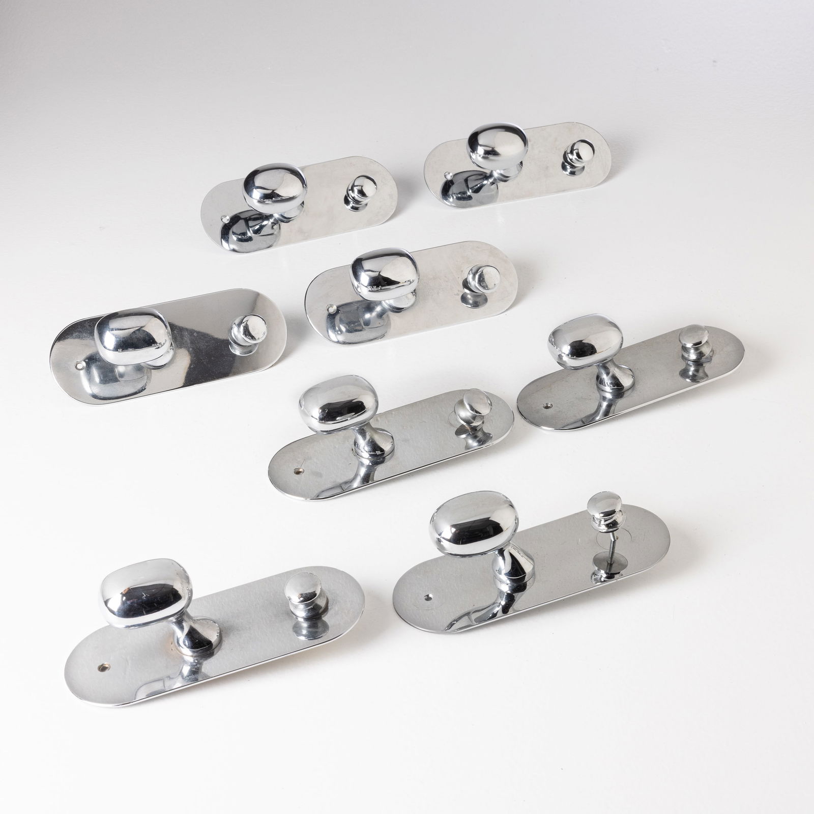 LUIGI CACCIA DOMINIONI: Otto appendiabiti mod. Super. Ottone cromato. Produzione Azucena 1962 ca. cm 20x7,5x8 EIGHT COAT HANGERS BY L. C. DOMINIONI Buone condizioni generali. Piccole righe, leggeri graffi, normali segni