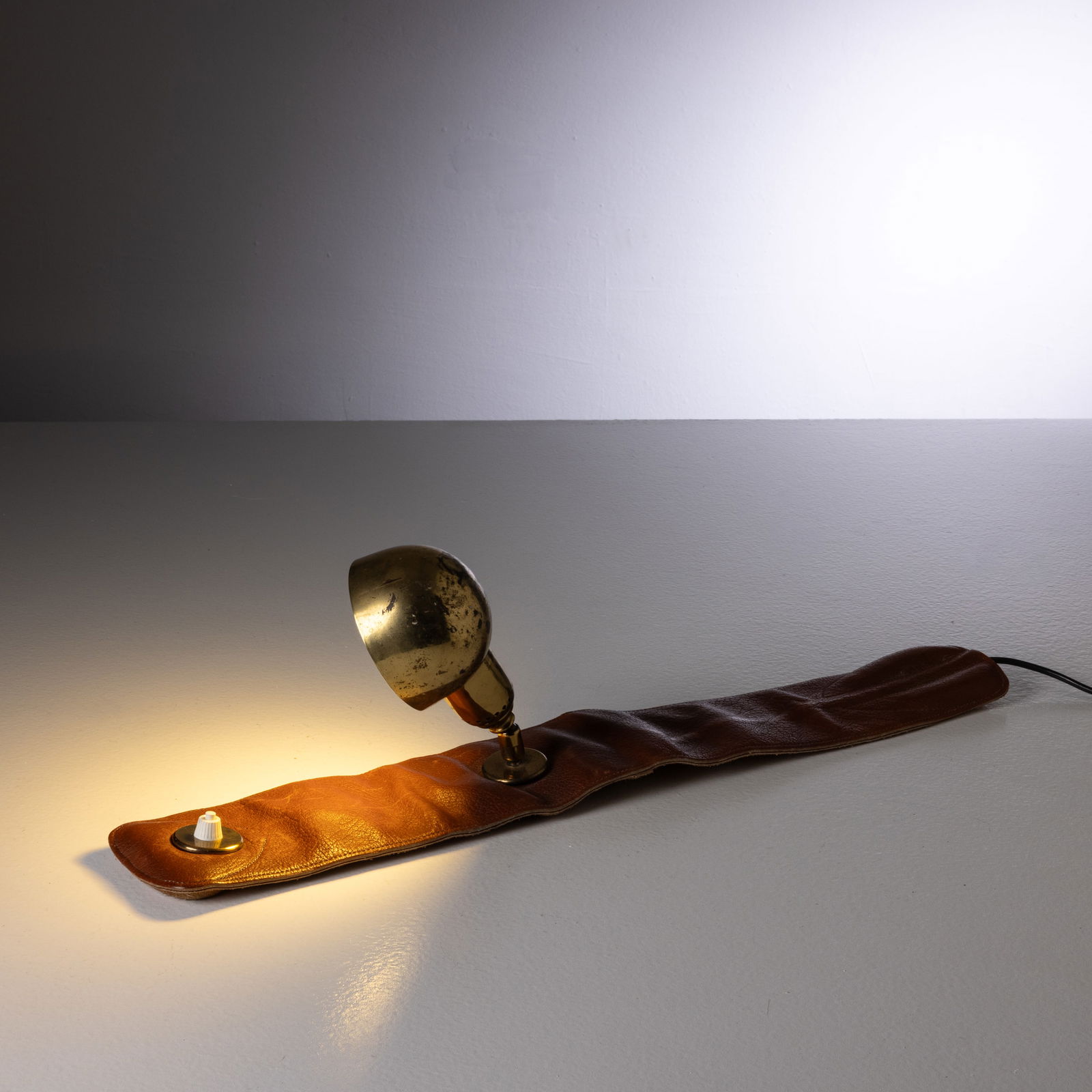 LUIGI CACCIA DOMINIONI: Lampada da lettura mod. LP01. Cuoio imbottito ottone. Produzione Azucena anni '80. cm 60x10; lampada cm 17x9x6 A LAMP BY L. CACCIA DOMINIONI Domus, n. 857, marzo 2003, p. 123 Condizioni molto