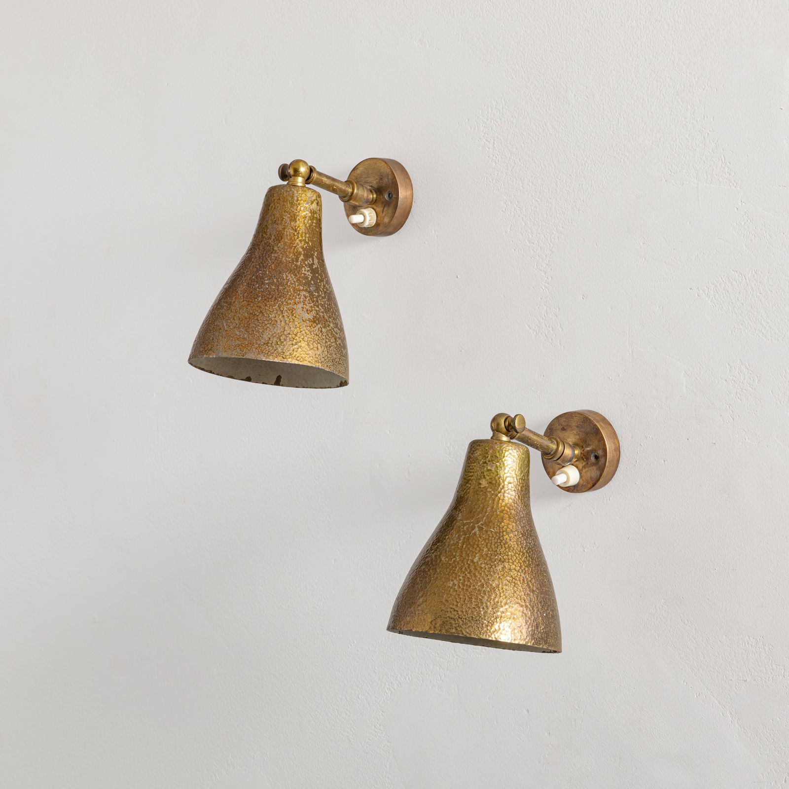 MANIFATTURA ITALIANA: Coppia di lampade da parete. Ottone martellato. Italia anni '50. cm 20x11x15 A APIR OF ITALIAN WALL LIGHTS Buone condizioni generali. Piccole righe, leggeri graffi, normali segni di usura. Trascurabil