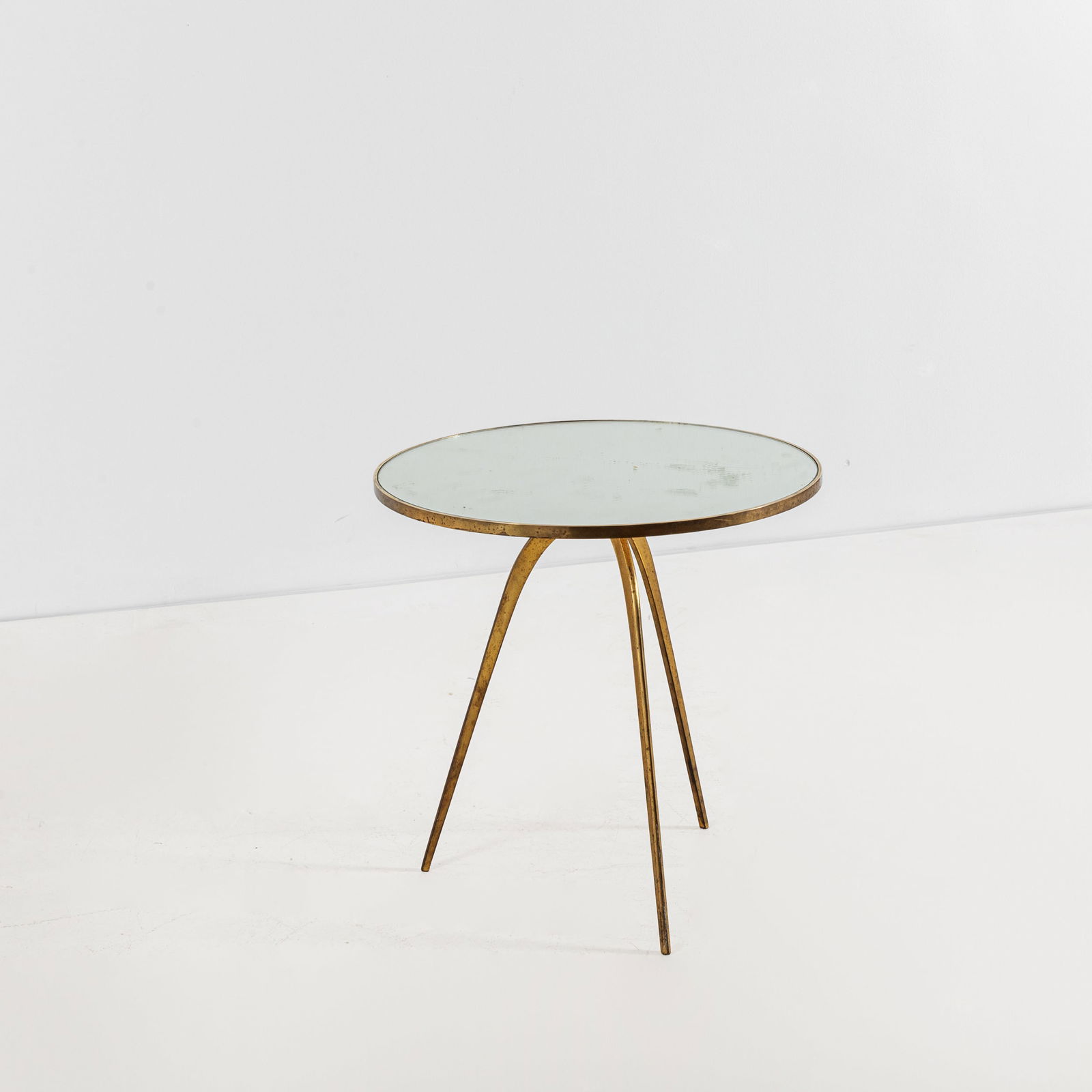 MANIFATTURA ITALIANA: Tavolino. Ottone, cristallo specchiato. Italia, anni '50. cm 52x56x56 AN ITALIAN SIDE TABLE Buone condizioni generali. Piccole righe, leggeri graffi, normali segni di usura. Lieve ossidazione. Ottone