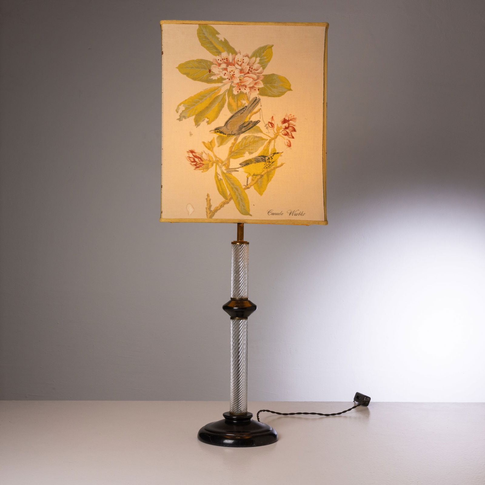 TOMMASO BARBI: Lampada da tavolo. Vetro trasparente a torchon e pasta di vetro nera lavorati a caldo, metallo, tessuto serigrafato. Italia anni '70. Etichetta del produttore sotto la base. Altezza con paralume cm