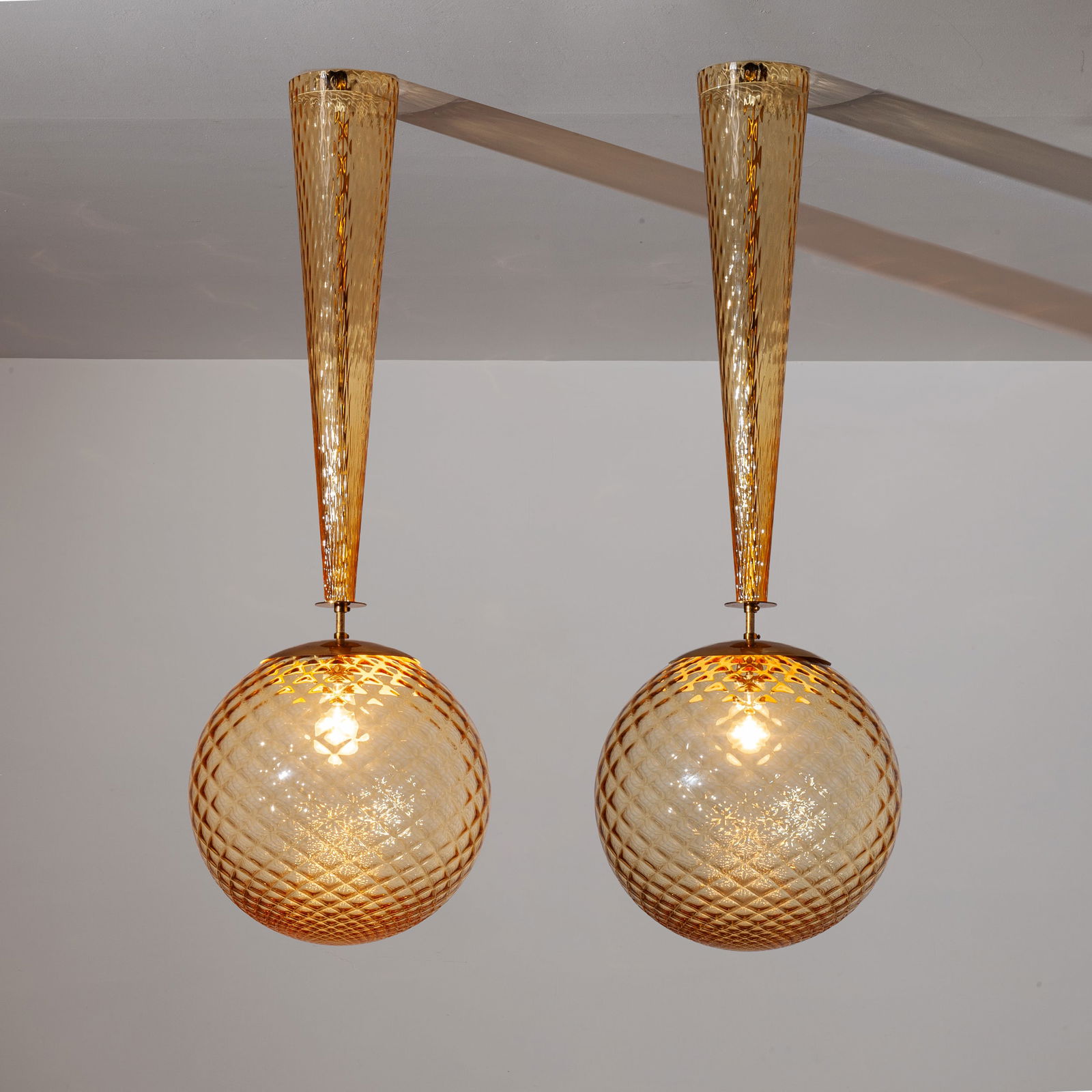 ERCOLE BAROVIER: Due lampade a sospensione. Metallo, vetro soffiato a stampo. Produzione Barovier & Toso, anni '80. cm 115x40x40 TWO CEILING LAMPS BY BAROVIER Buone condizioni generali. Piccole righe, leggeri