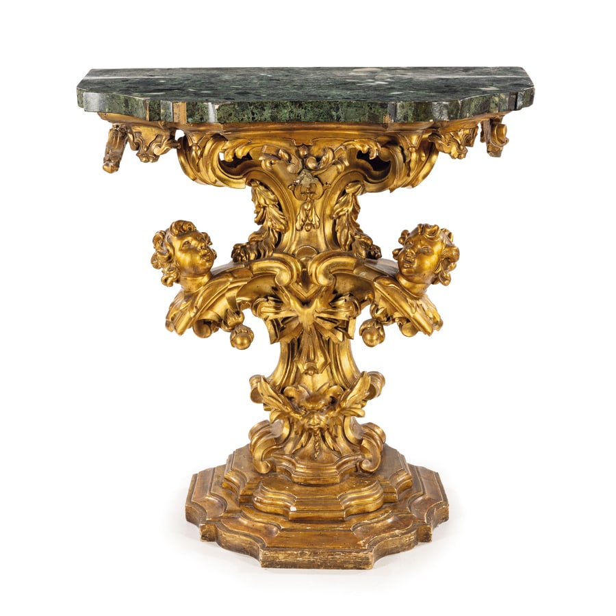 COPPIA DI CONSOLE IN LEGNO SCOLPITO E DORATO, ROMA,: INIZIO DEL XVIII SECOLO piano impiallacciato in marmo verde antico su mensola mistilinea, fusto a balaustro con teste di cherubini ai lati e mascherone grottesco alla base, piede gradinato; difetti, c