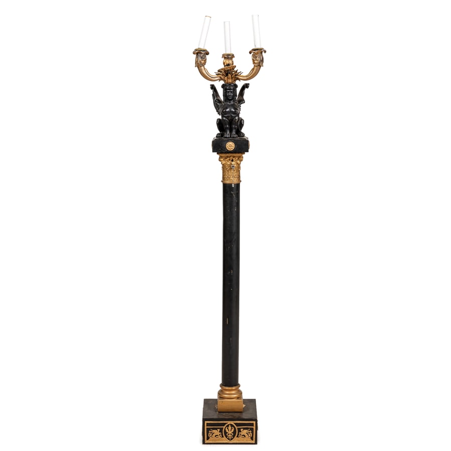 CANDELABRO DA TERRA IN BRONZO DORATO E PATINATO, XX: SECOLO di gusto Impero su colonna con capitello e base quadrata, a tre fiamme sorrette da sfinge alata; difetti, pochi graffi, alcune parti da fissare, elettrificato non funzionante Cm 140X27 Sfinge,