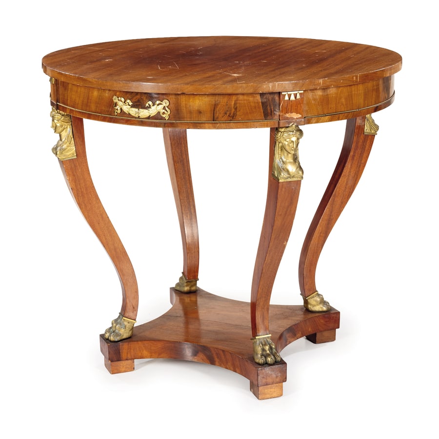 GUERIDON IMPIALLACCIATO IN LEGNO DI NOCE, INIZIO DEL: XX SECOLO di gusto classico a sezione circolare, gambe mistilinee con testine muliebri e piedi ferini In bronzo dorato, mensola di raccordo quadripartita; difetti, graffi e ingiallimenti nella vernice