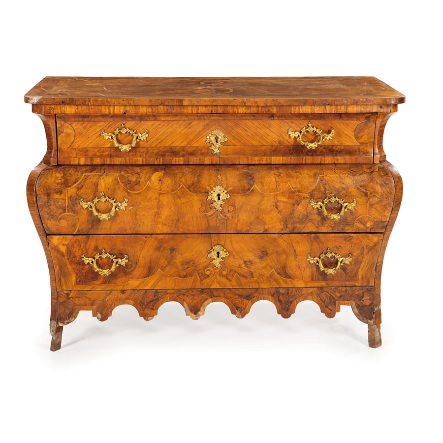 CASSETTONE IMPIALLACCIATO IN LEGNI VARI, XVIII SECOLO: a doppia bombatura e tre cassetti nel fronte, decoro a riserve mistilinee intarsiato in legno chiaro; difetti, rotture e mancanze nell'impiallacciatura e nelle gambe, fenditura nel piano, restauri, le