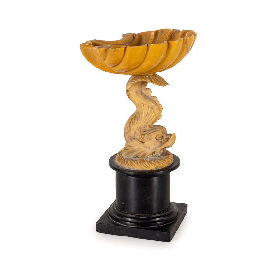 ALZATA IN MARMO GIALLO, XIX SECOLO: come conchiglia su tritone fantastico e base a plinto in marmo nero; difetti, restauro nella conchiglia e nel basamento Cm 16X9X9 A YELLOW MARBLE CENTERPIECE, 19TH CENTURY; DEFECTS, RESTORATION TO THE