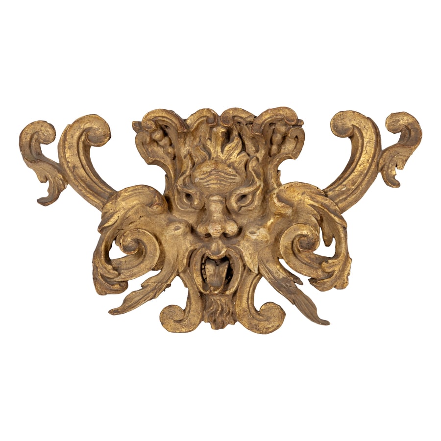 FREGIO IN LEGNO INTAGLIATO E DORATO, XVIII SECOLO: raffigurante mascherone grottesco con terminali a voluta; difetti, mancanze nella doratura, parte di fregi con rifacimento, restauri Cm 28X51X7 A CARVED AND GILDED WOODEN FRIEZE, 18TH CENTURY; DEFECTS