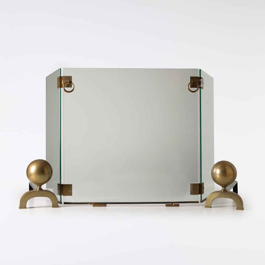 JACQUES ADNET (ATTRIB. A): Due alari e para scintille. Ferro, ottone, cristallo temperato. Francia anni '50. para scintilla cm 61x87x30 ca; alari cm 21x17x43 A PAIR OF ANDIRONS AND FIRE SCREEN ATTRIBUTED TO J. ADNET Buone