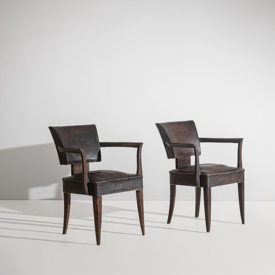 TOMASO BUZZI (ATTTRIB. A): Due poltroncine. Legno di noce tinto, cuoio imbottito. Italia, 1930 ca. 80x62x60 A PAIR OF ARMCHAIRS ATTRIBUTED TO T. BUZZI Buone condizioni. Piccole righe, segni di usura, piccole mancanze, rinforzi